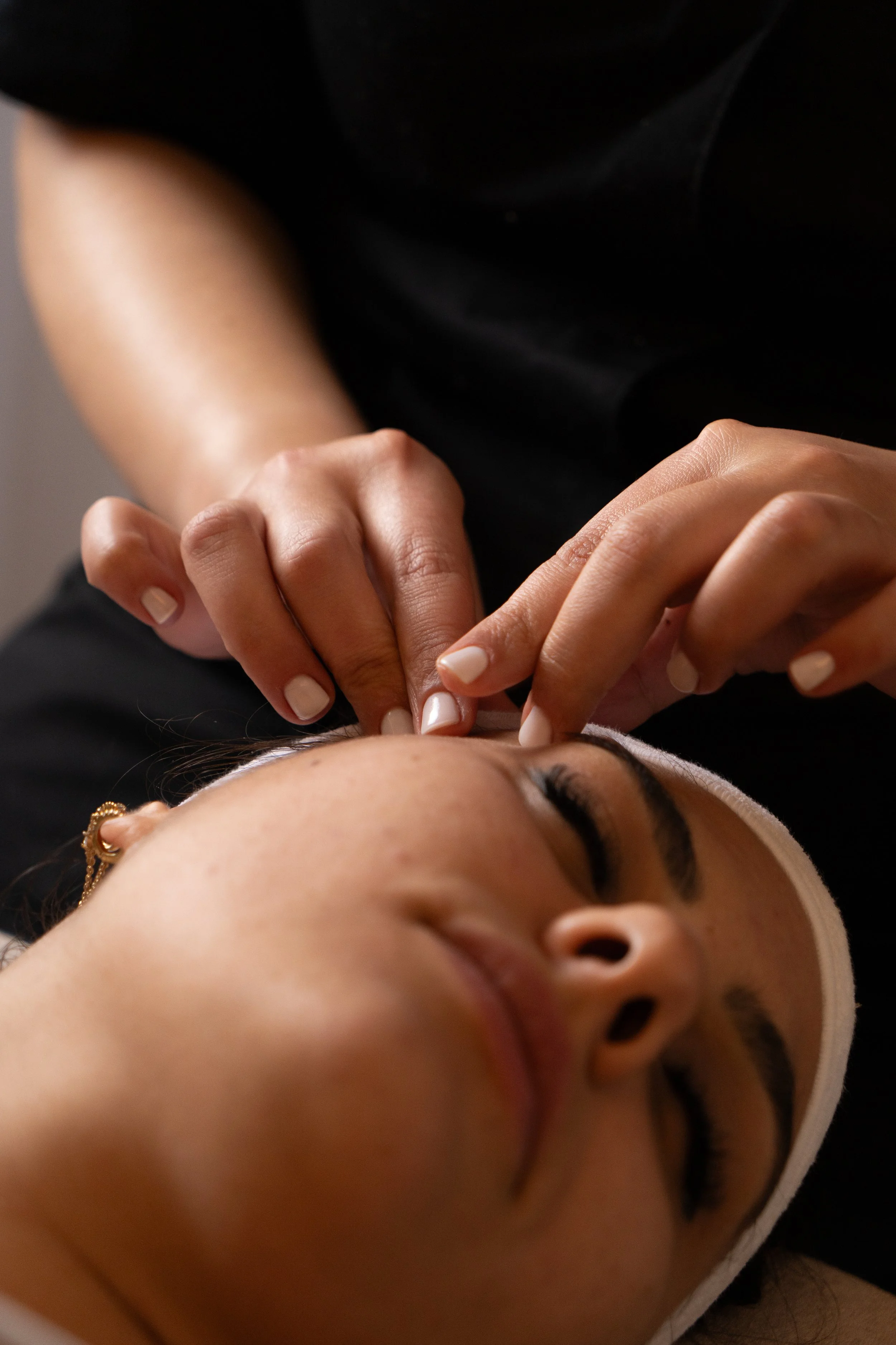 Une personne qui reçoit un soin du visage ou un massage du visage dans un spa ou un centre de bien-être.