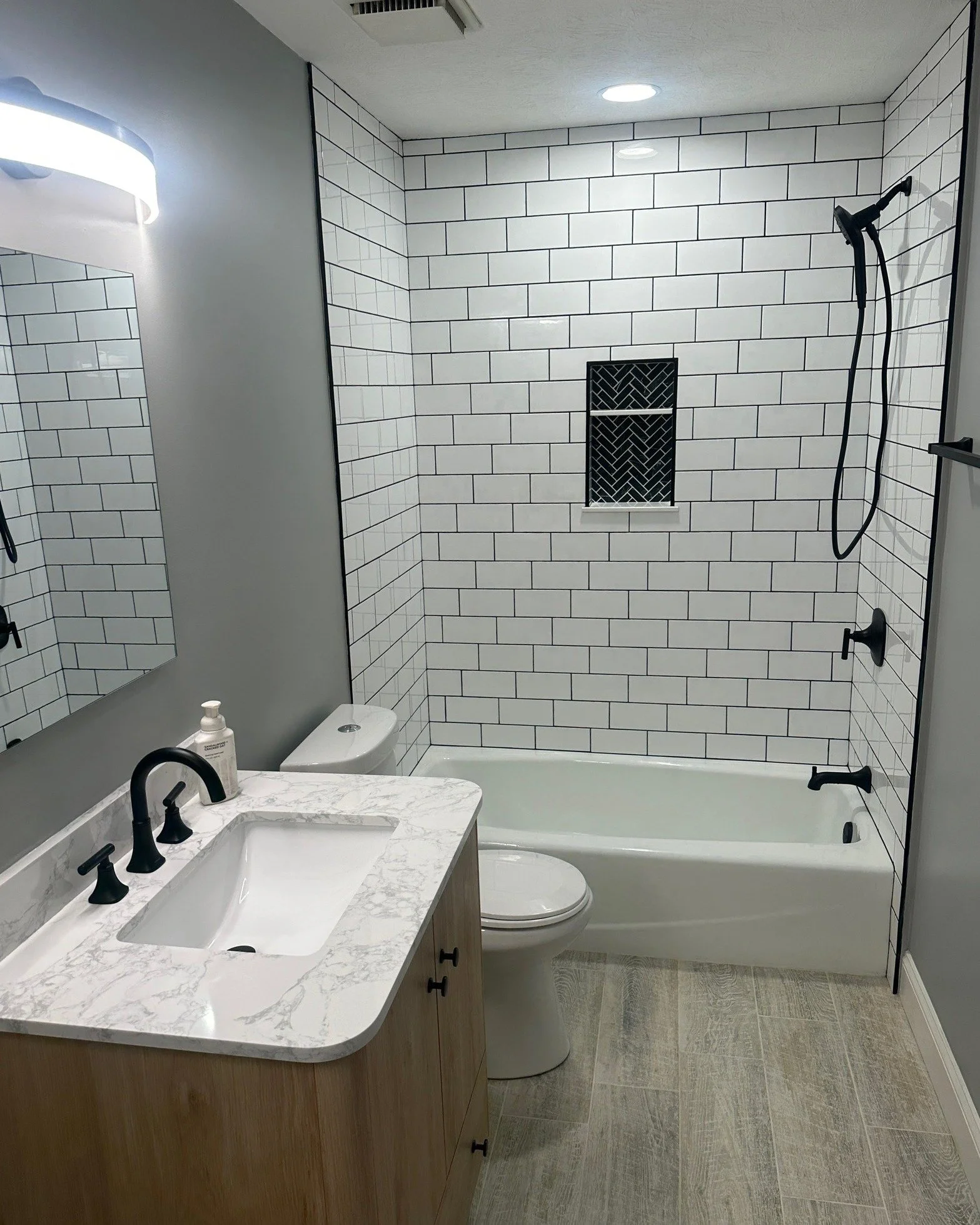 Before &amp; After Bathroom Remodel
From dated and closed-in to clean, bright, and built for everyday comfort.
This bathroom renovation features fresh subway tile, bold black fixtures, a custom herringbone shower niche, updated flooring, and a modern