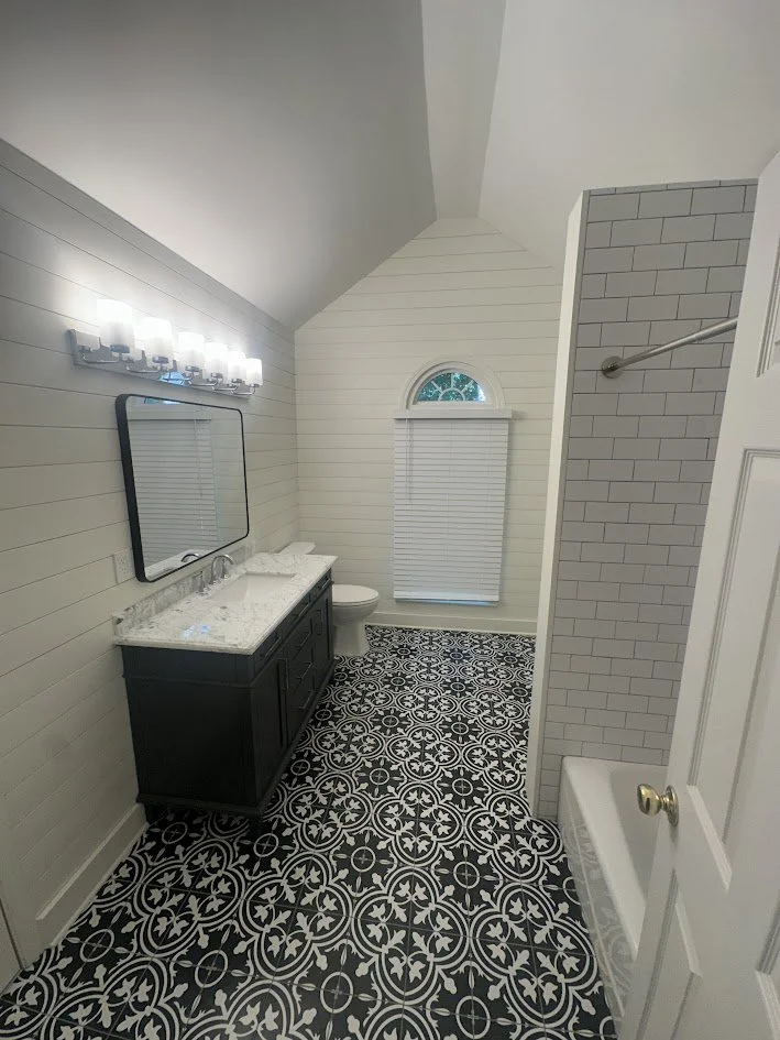 Master bathroom remodel with shiplap accent walls, black vanity, and bold patterned tile floor — Centerline Construction, Canton GA