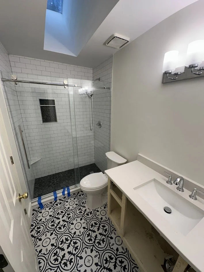 Fiberglass tub converted to walk-in tile shower with subway tile, glass door, and patterned floor — Centerline Construction North Georgia