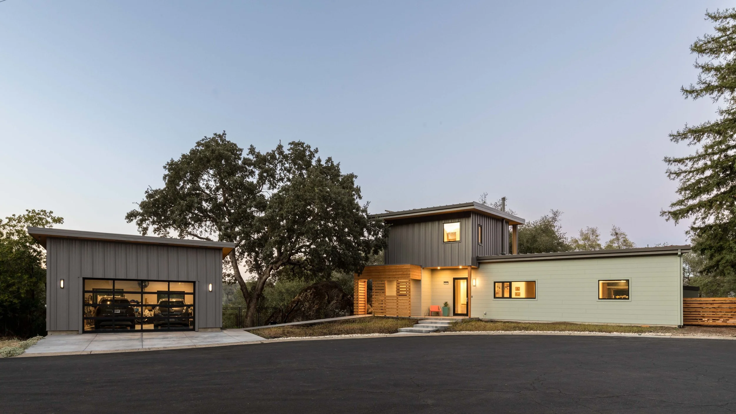The singular native oak tree and scupltural rock are framed by the house on one side and the detached garage on the other