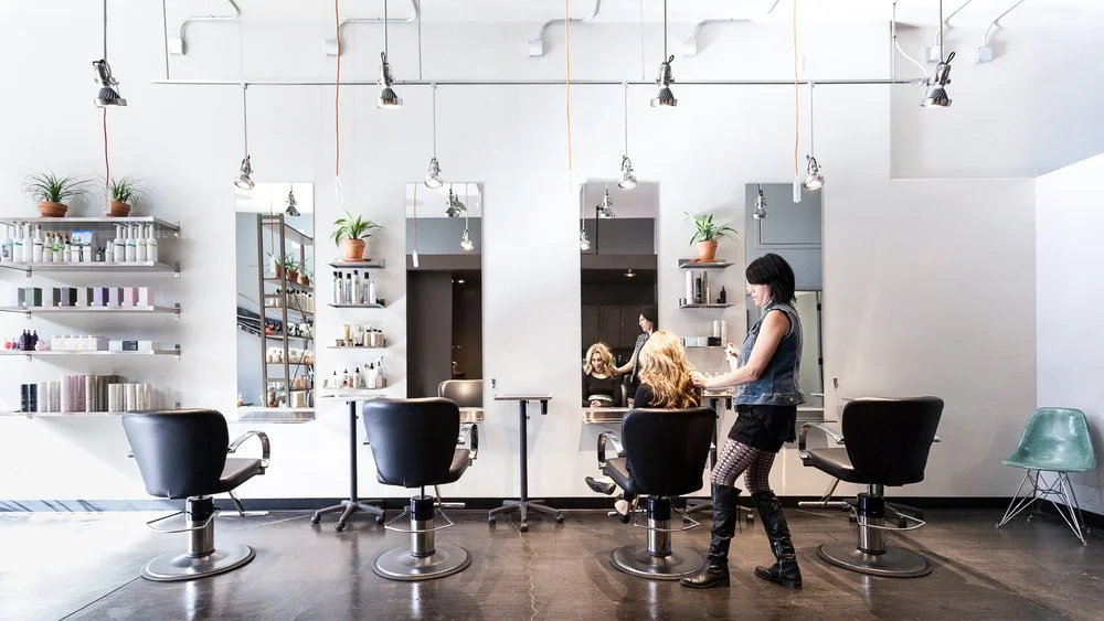 Modern hair salon interior with stylist working on a client's hair.