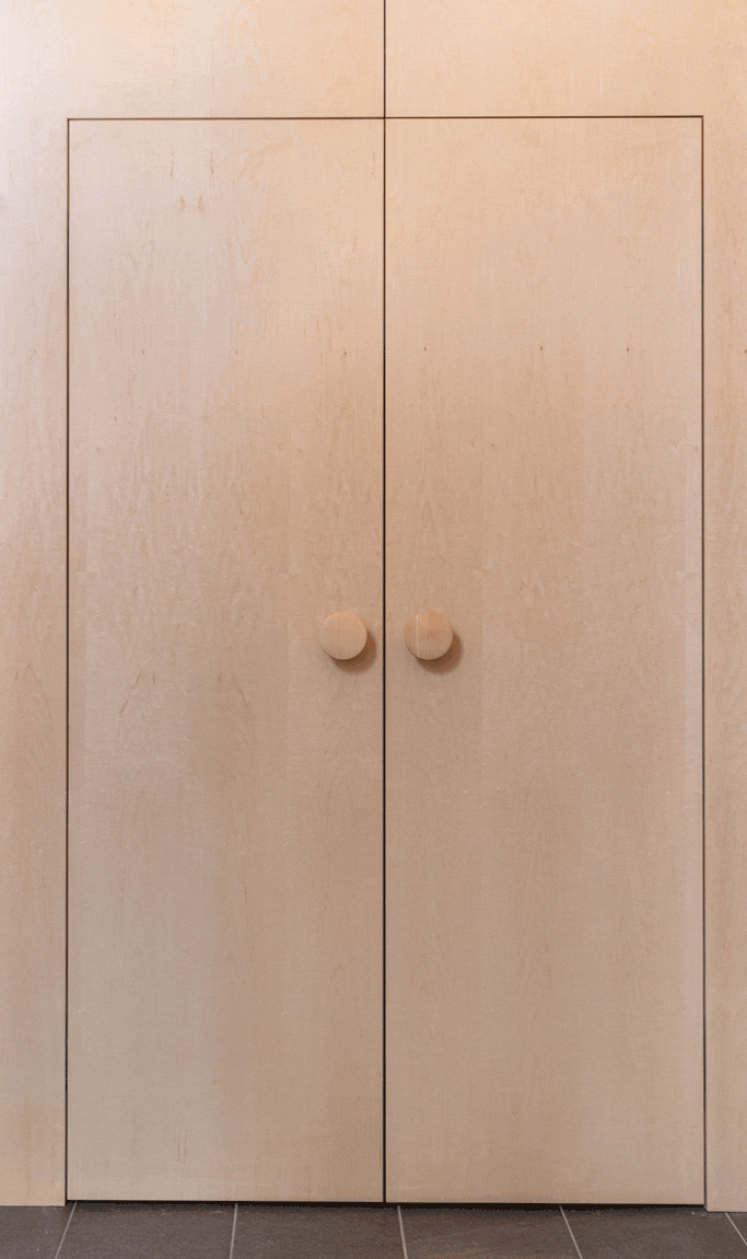 Animated image of wooden cabinet doors opening to reveal a hidden gray door behind them.