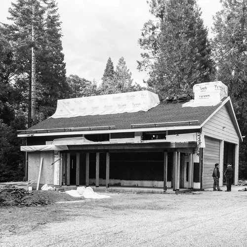 Black and white photo of a partially constructed garage with people