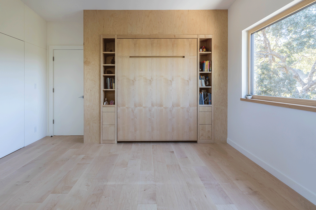 Animation of a room with a foldable Murphy bed opening and closing, showing built-in shelves and a large window with a scenic view.