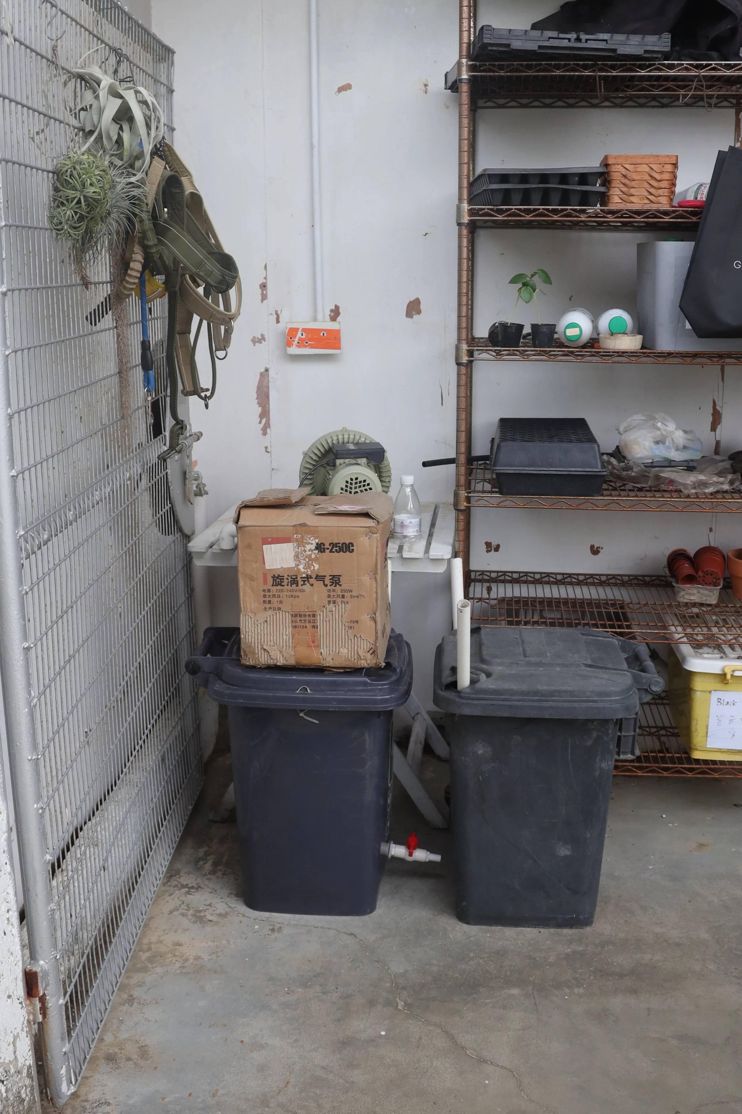 Two black buckets and a box on top