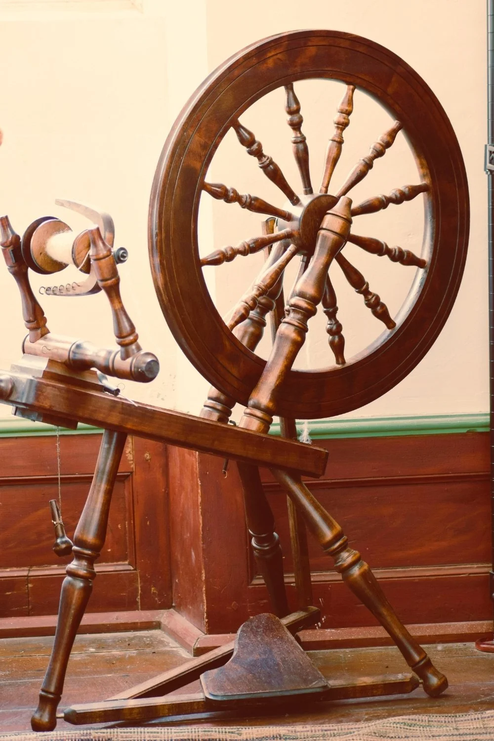 Old-world spinning wheel symbolizing Frigg’s fate-weaving for a handmade scented mythology candle with a clean-burning wooden wick.