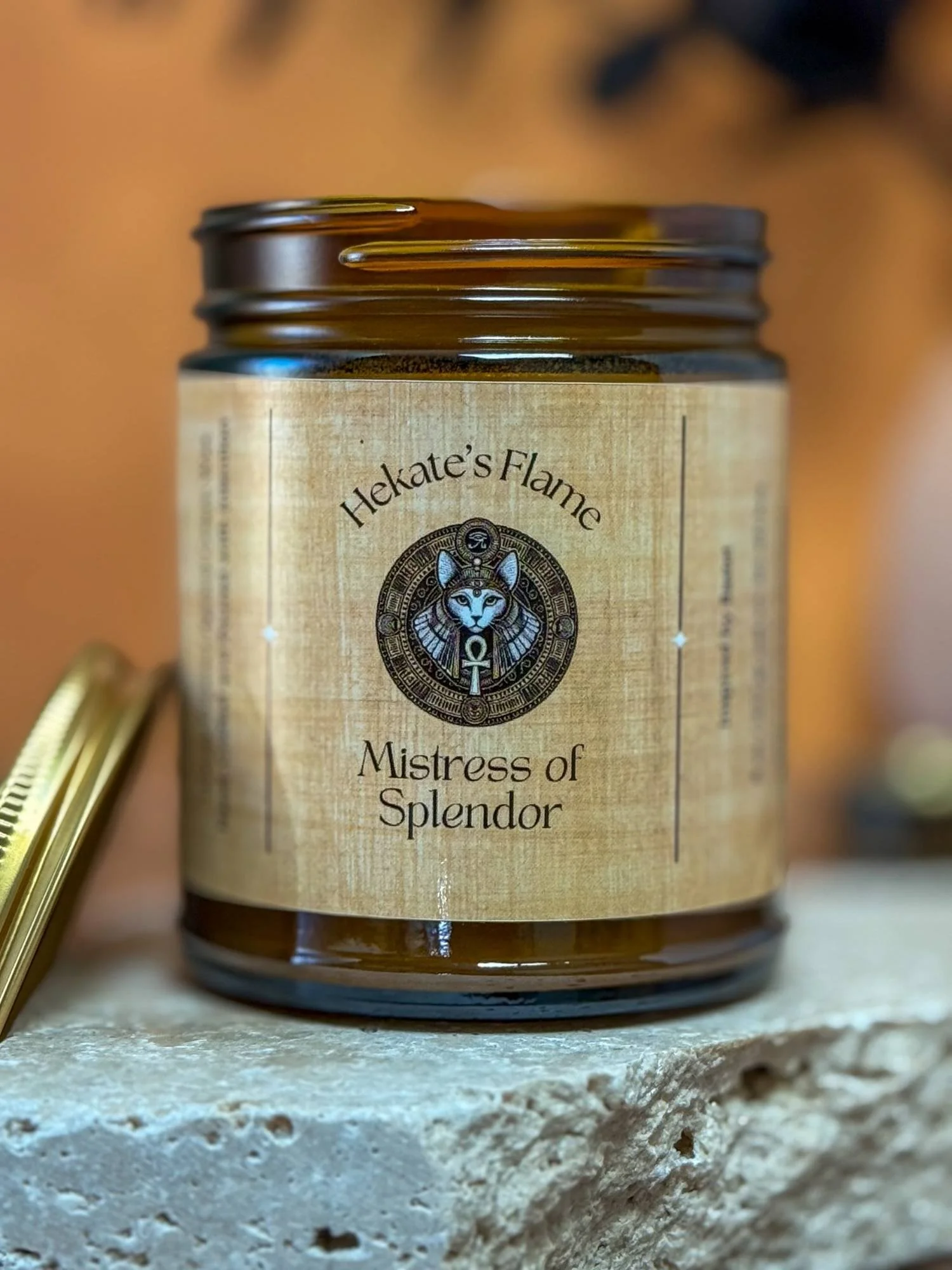 Handmade Bastet candle in amber jar with papyrus-style label, goddess-inspired Mistress of Splendor.