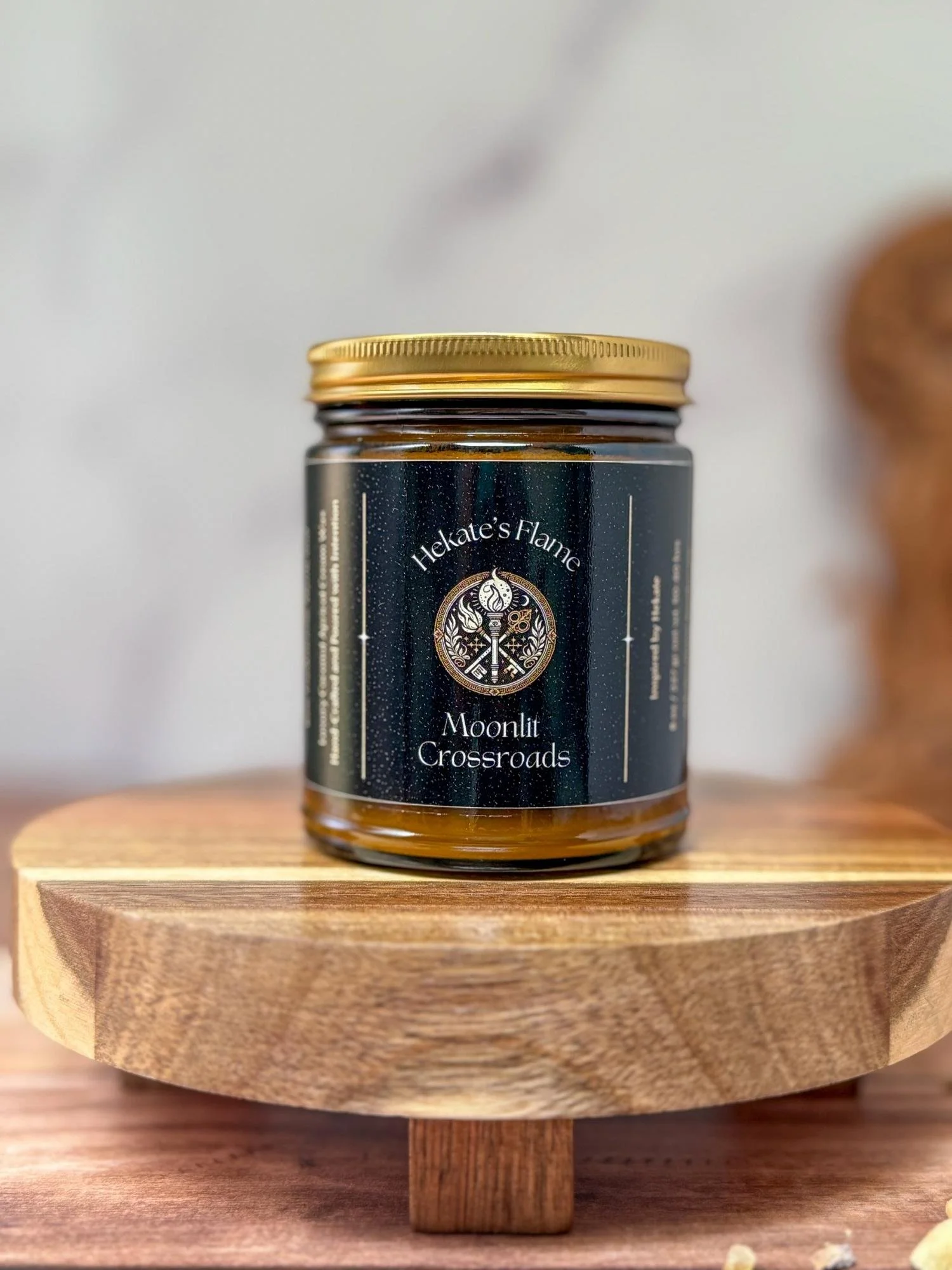 Mythology-inspired Moonlit Crossroads candle in amber jar with gold metal lid, eco-conscious and hand-poured luxury candle.