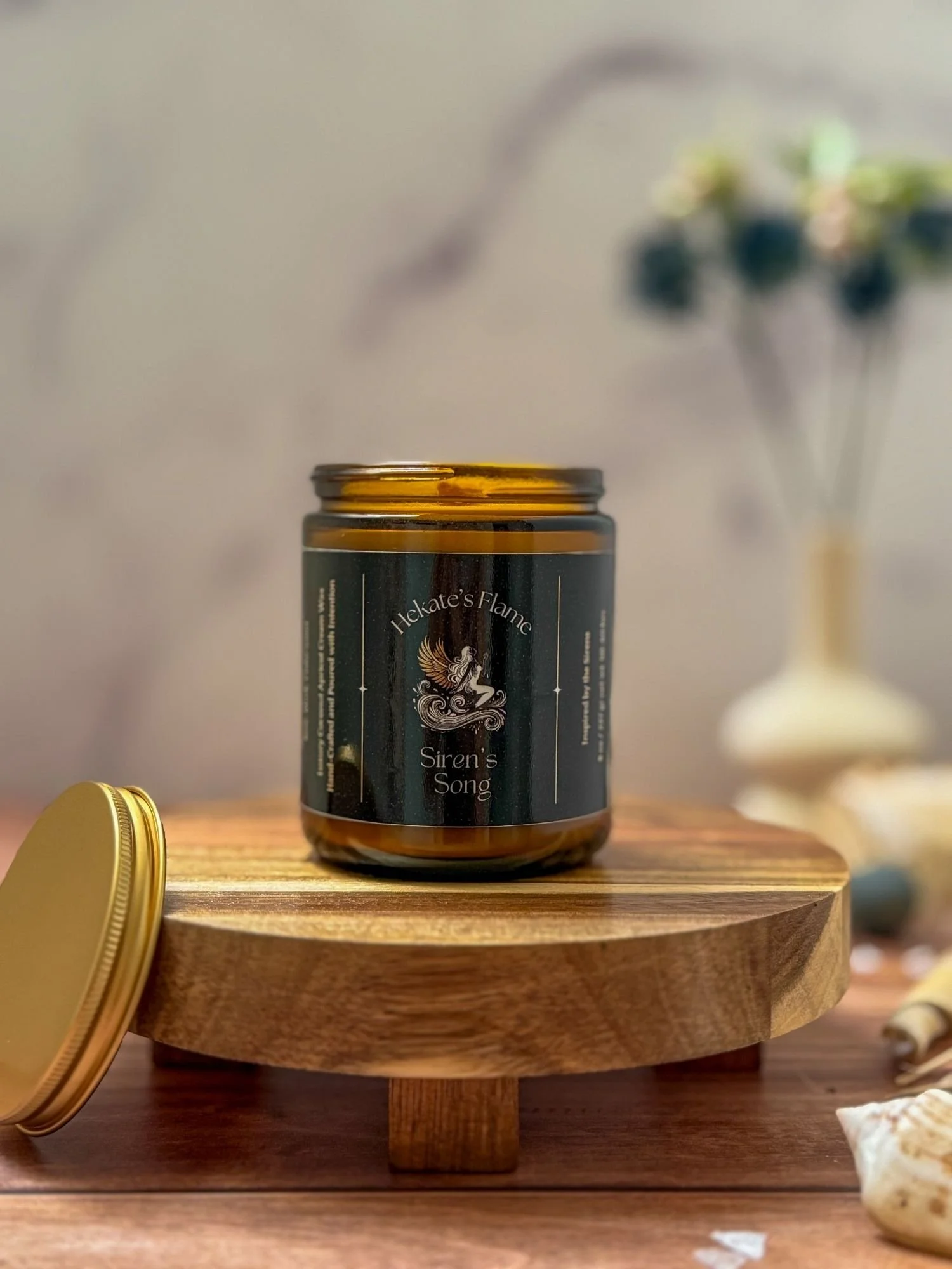 Hand-poured Siren’s Song mythology candle in amber jar with gold lid, eco-conscious coconut apricot wax and wooden wick.