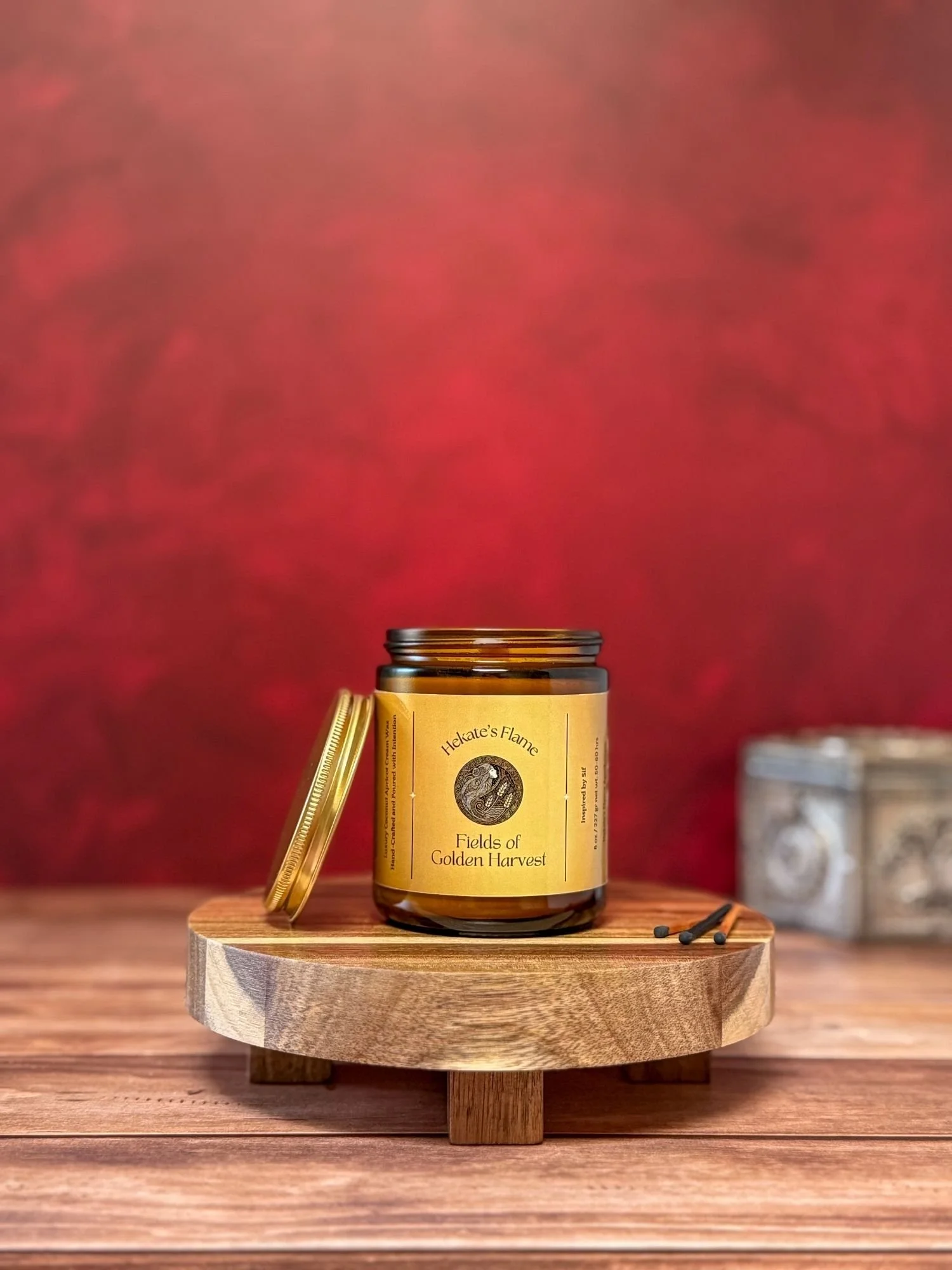 Amber glass jar with open gold lid, Sif Norse goddess mythology candle, coconut apricot wax, hand-poured and sustainable.