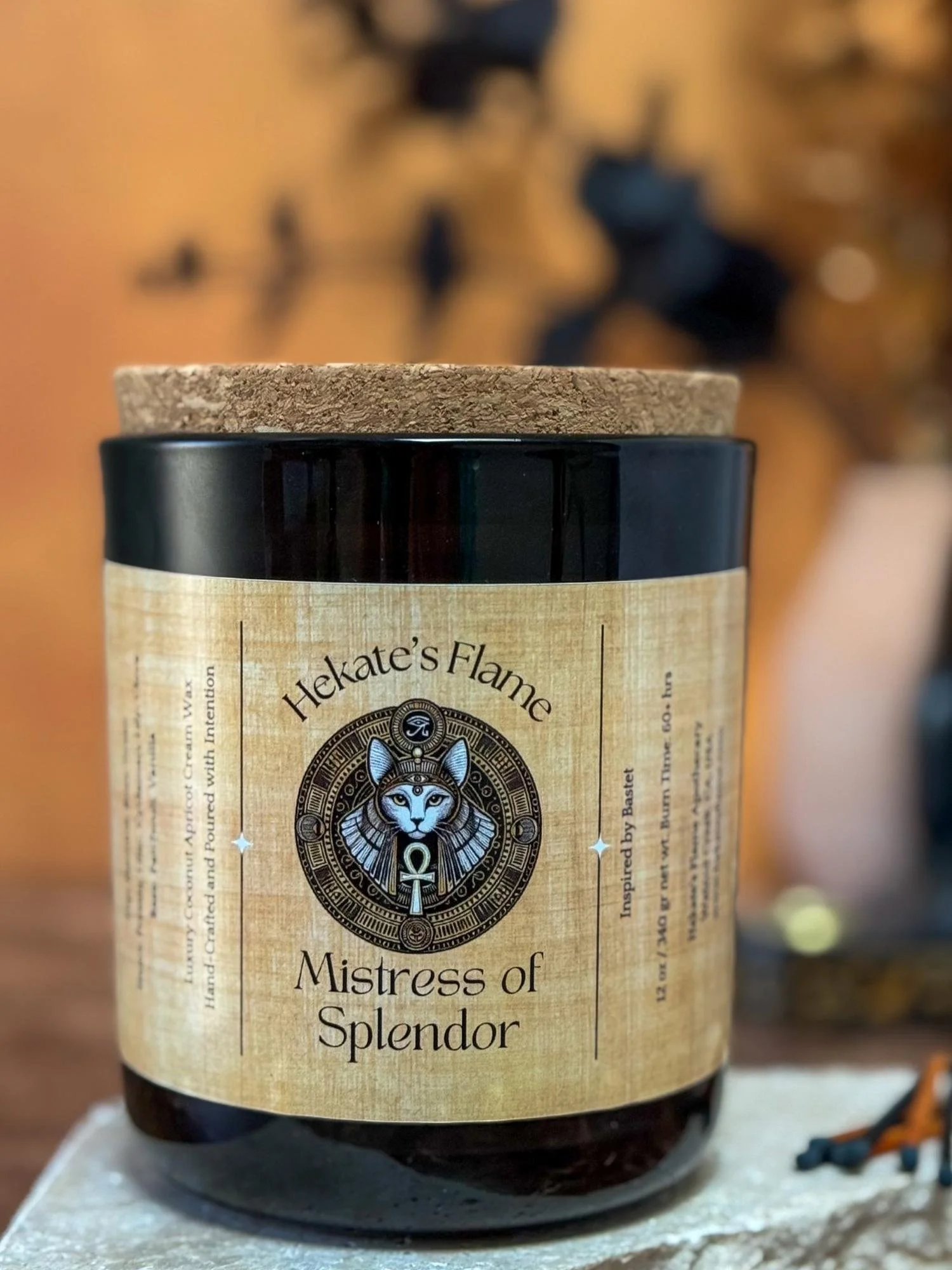 Hand-poured mythology candle in dark glass, dedicated to Bastet, goddess of cats, music, and joy.