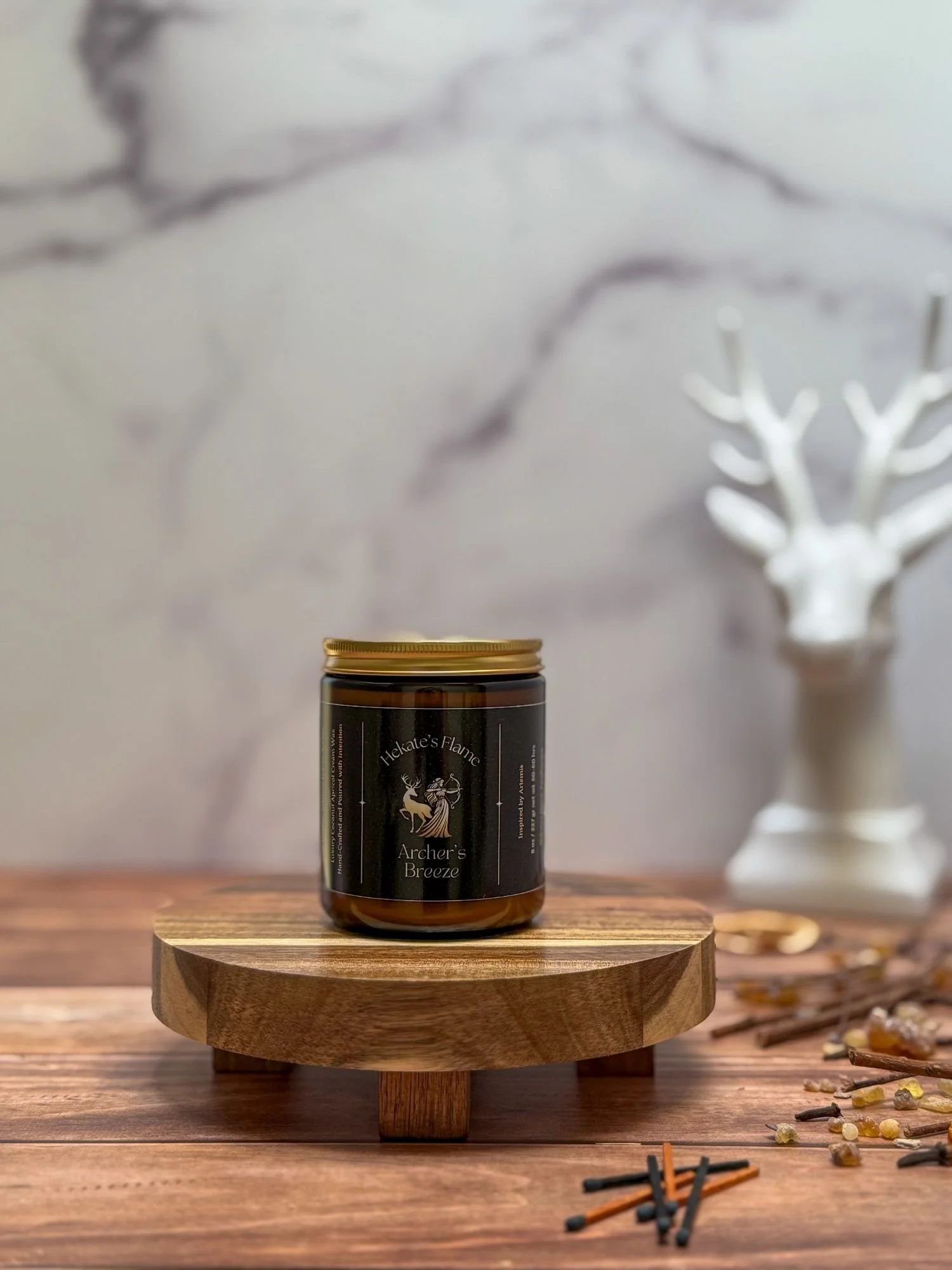 Eco-conscious Greek goddess candle Archer’s Breeze, amber glass with gold metal lid, luxury hand poured mythology candle.