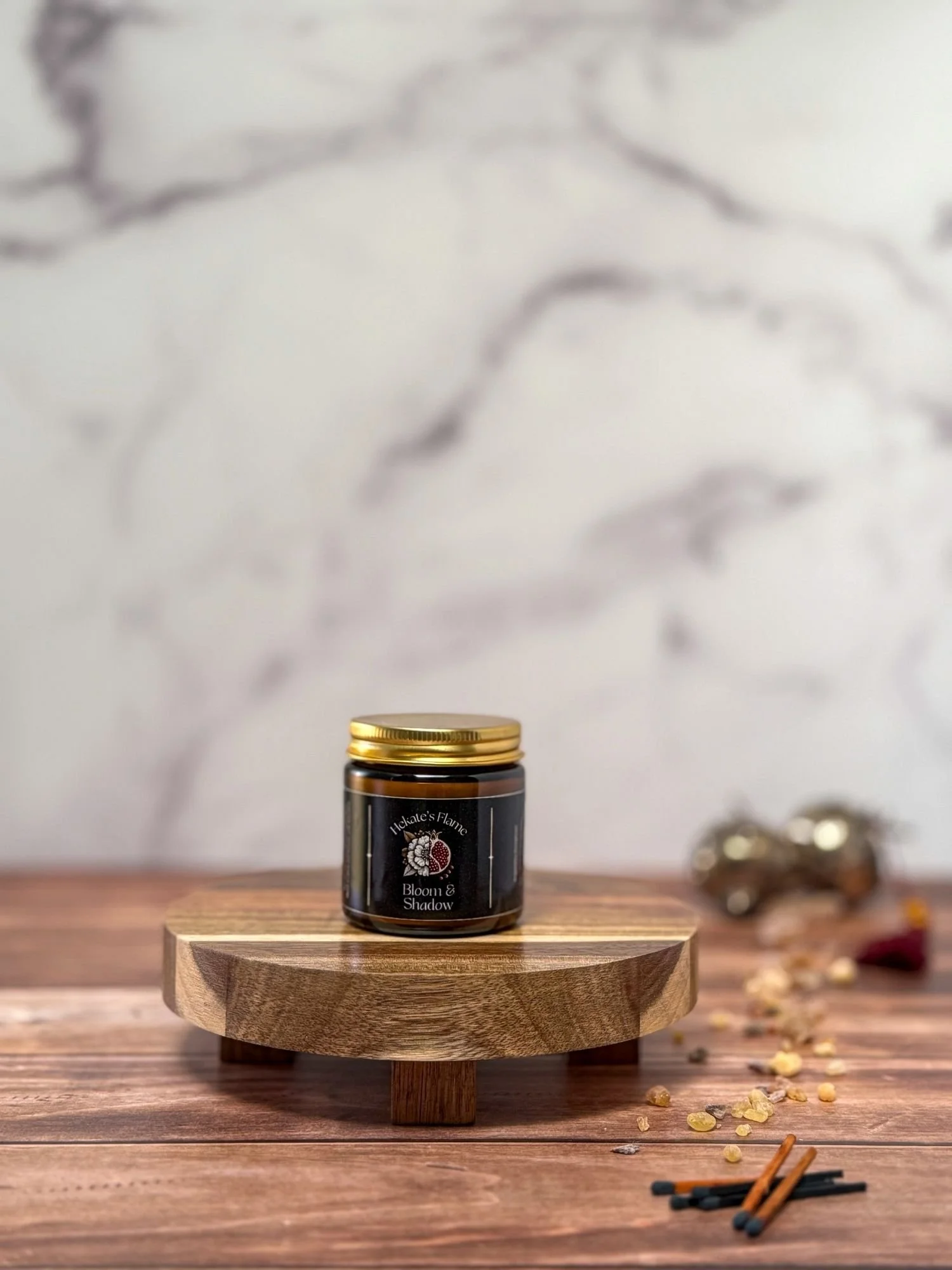 Bloom & Shadow handcrafted amber glass candle, gold lid removed, homemade eco-conscious Greek mythology candle.