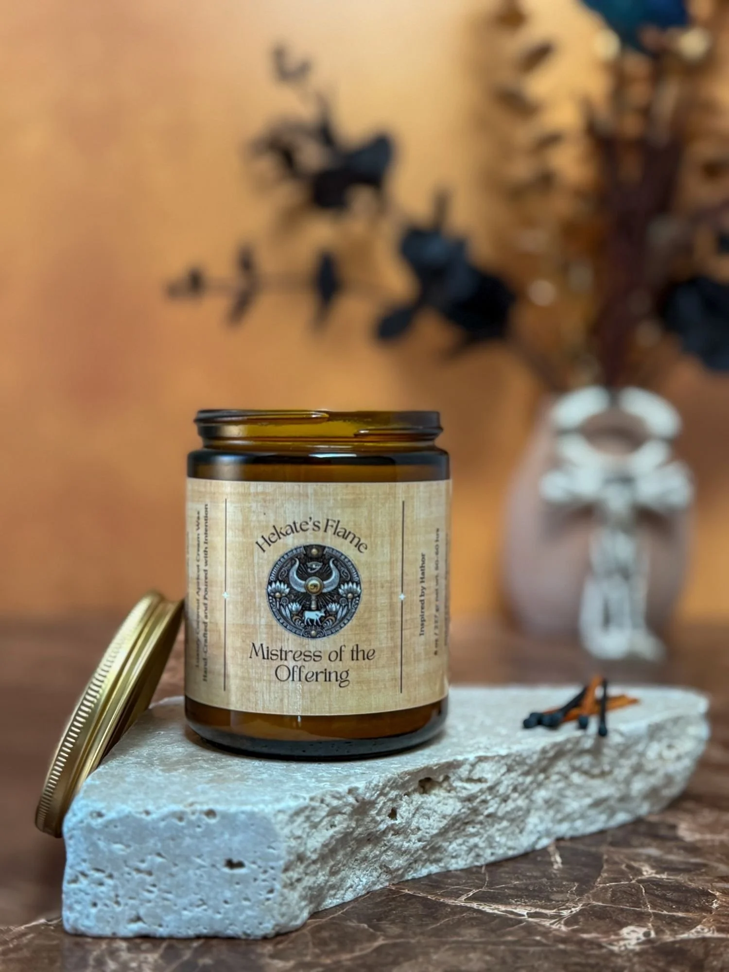 Handmade Hathor candle in amber glass jar with open gold lid, handcrafted coconut apricot wax, Egyptian mythology candle.