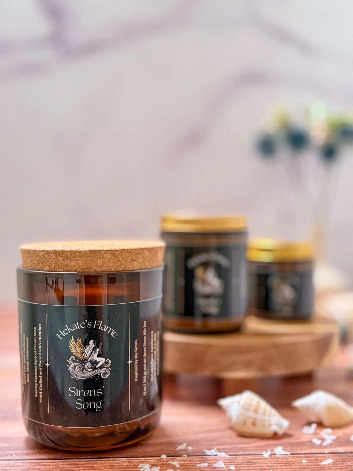Mythology-inspired Siren’s Song candle collection in amber jars with cork and gold lids, handmade coconut apricot wax candles.