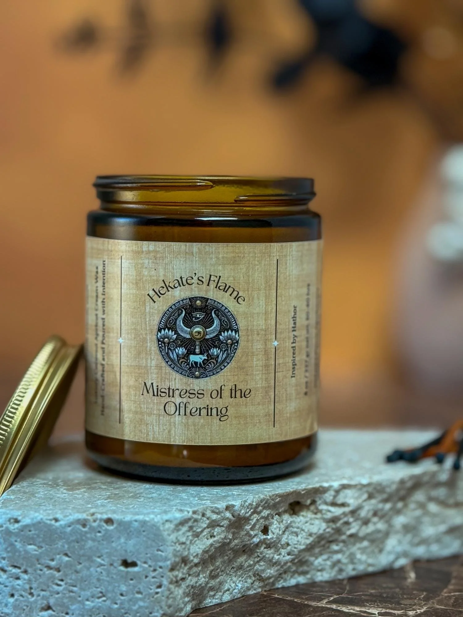 Luxury handcrafted amber glass candle, Hathor goddess design, eco-conscious coconut apricot wax with wooden wick.
