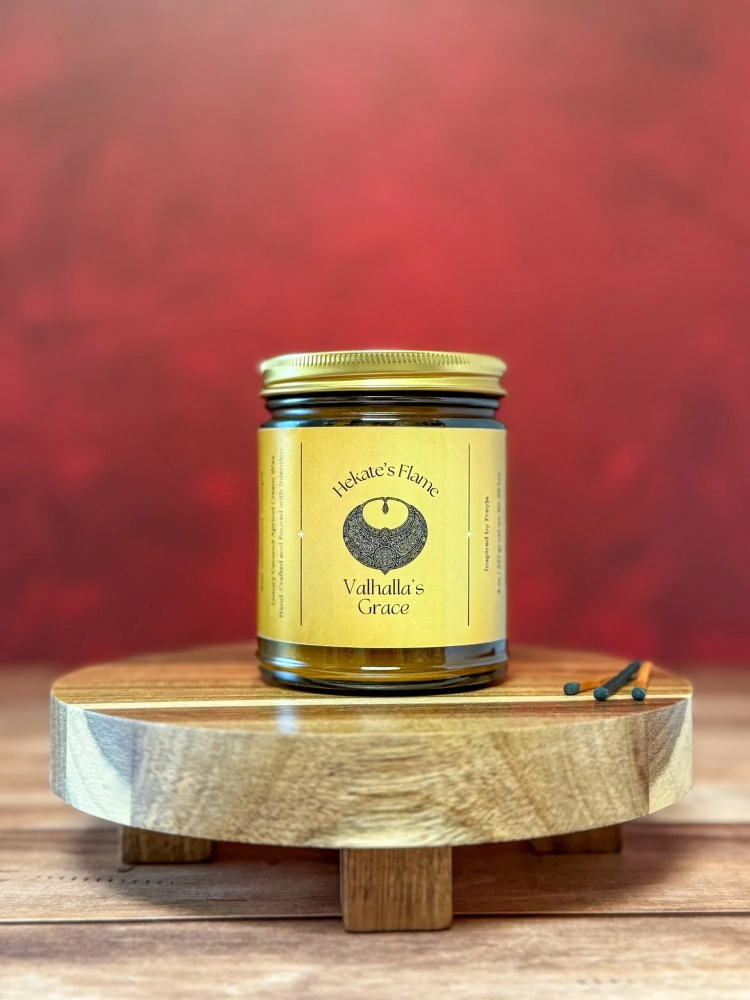 Helheim’s Mist handmade mythology candle in amber glass with gold metal lid, coconut apricot wax and wooden wick, eco-conscious Norse goddess-inspired candle.