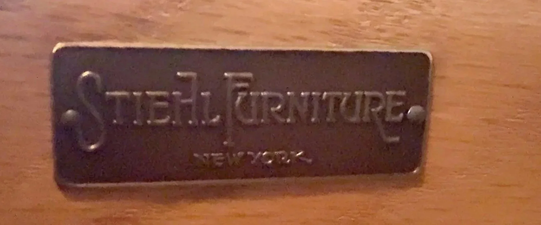 close-up of a stiehl furniture maker’s label on a vintage wooden piece