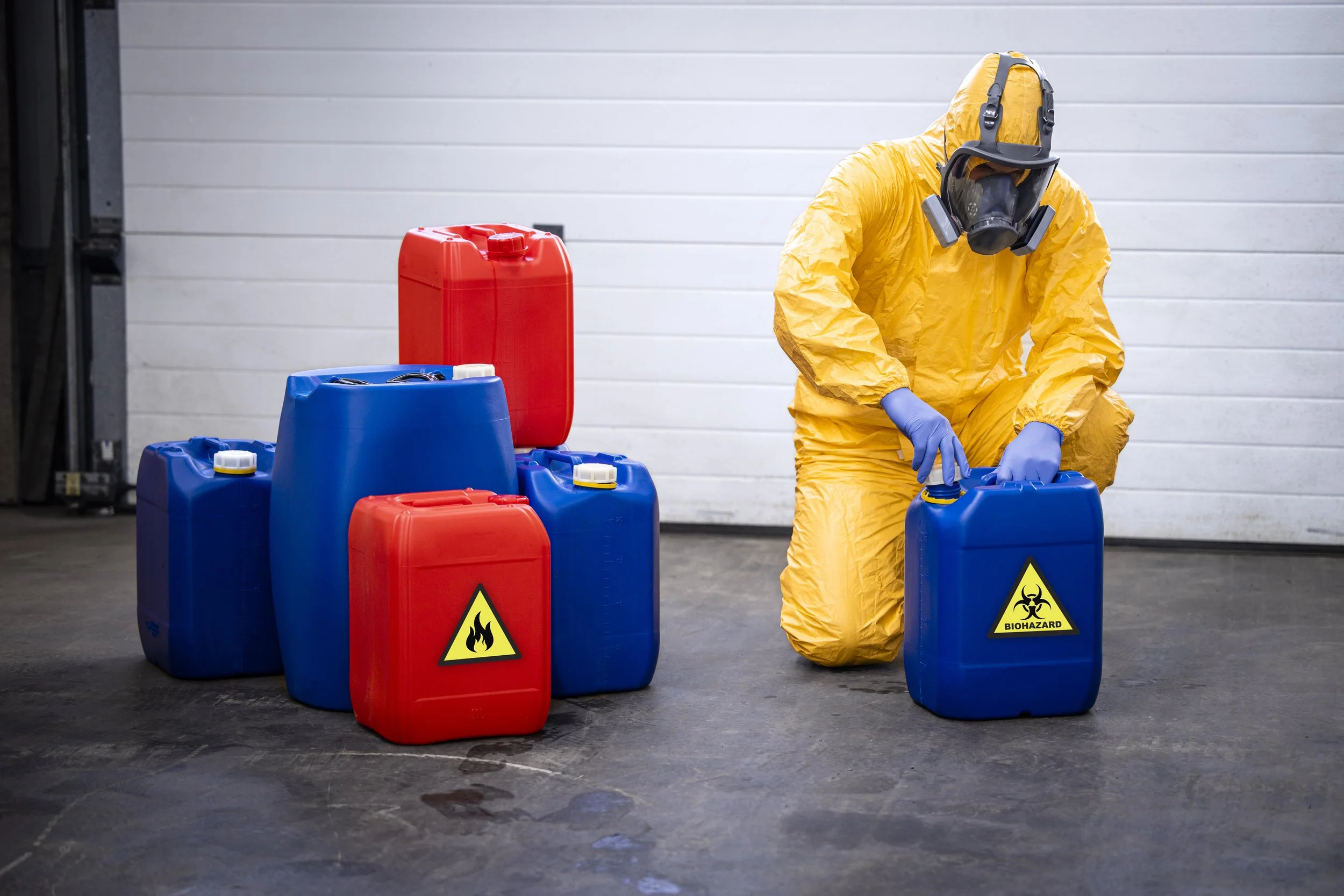 man in hazardous material suit closing a chemical container