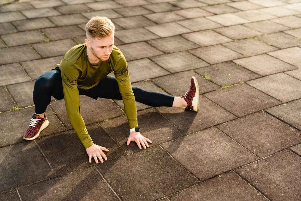 Man performing a lateral mobility stretch to improve hip flexibility and range of motion.