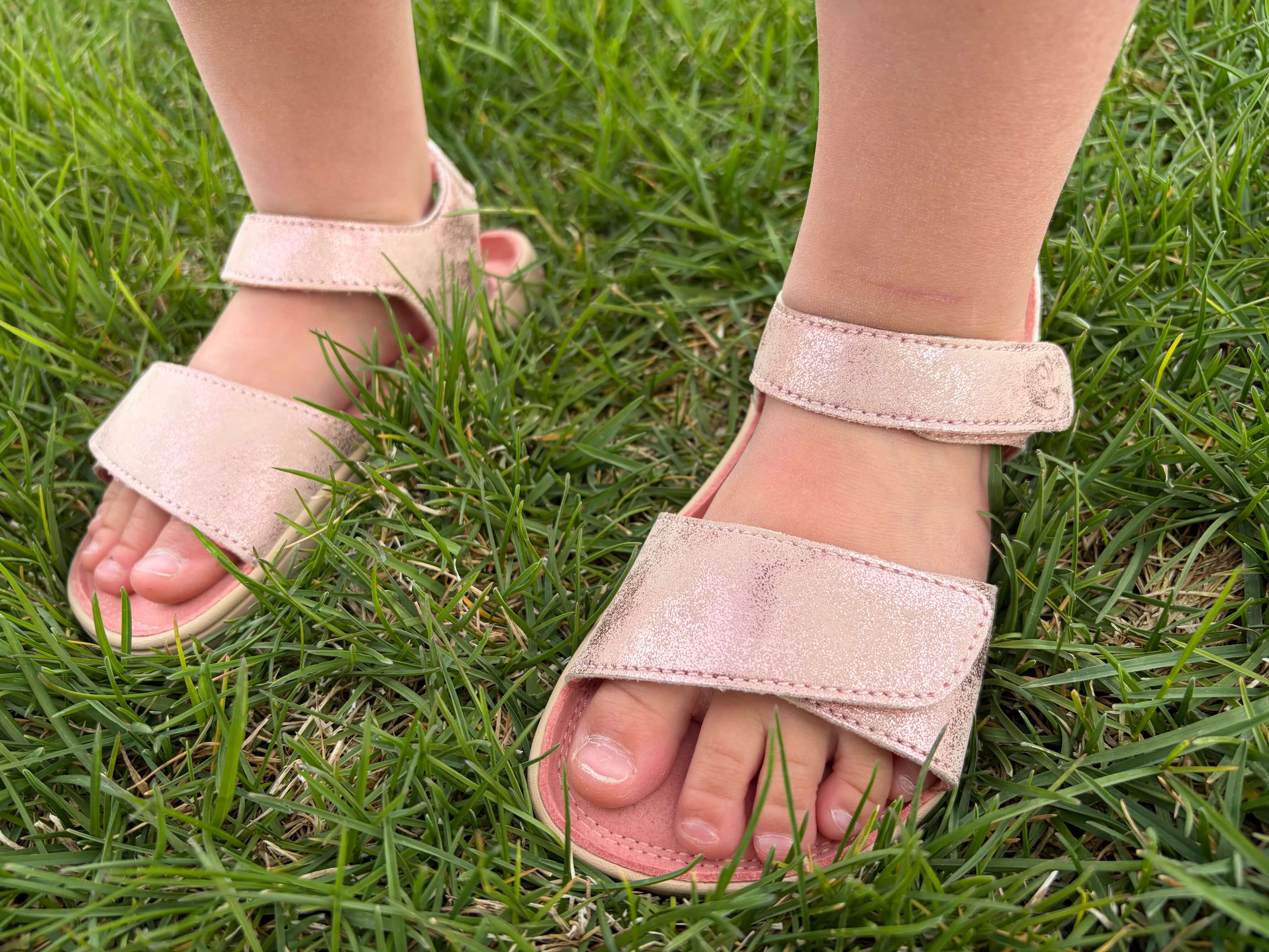 kid wearing the be lenka Miami Kids barefoot sandals in Coral Sparkle