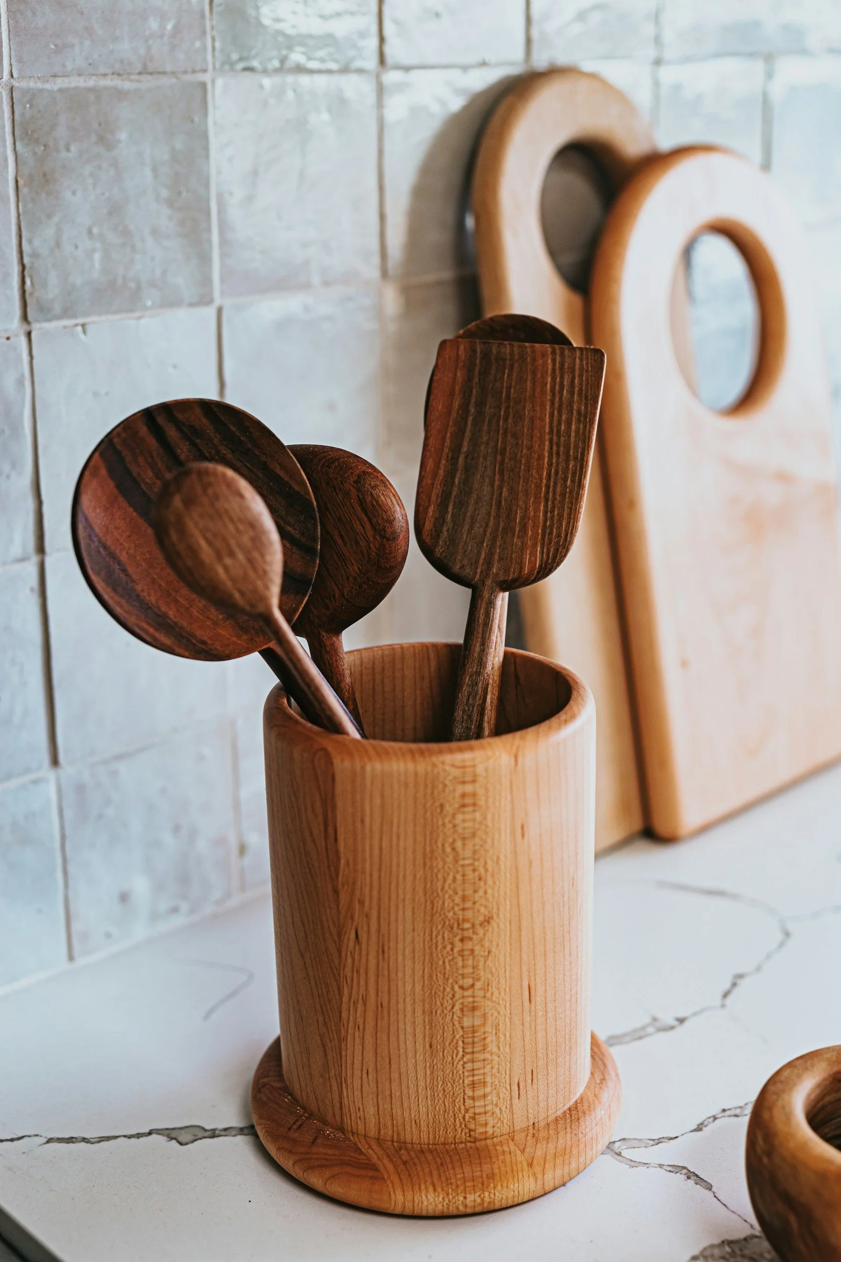 wooden cup filled with wooden spoons in kitchen