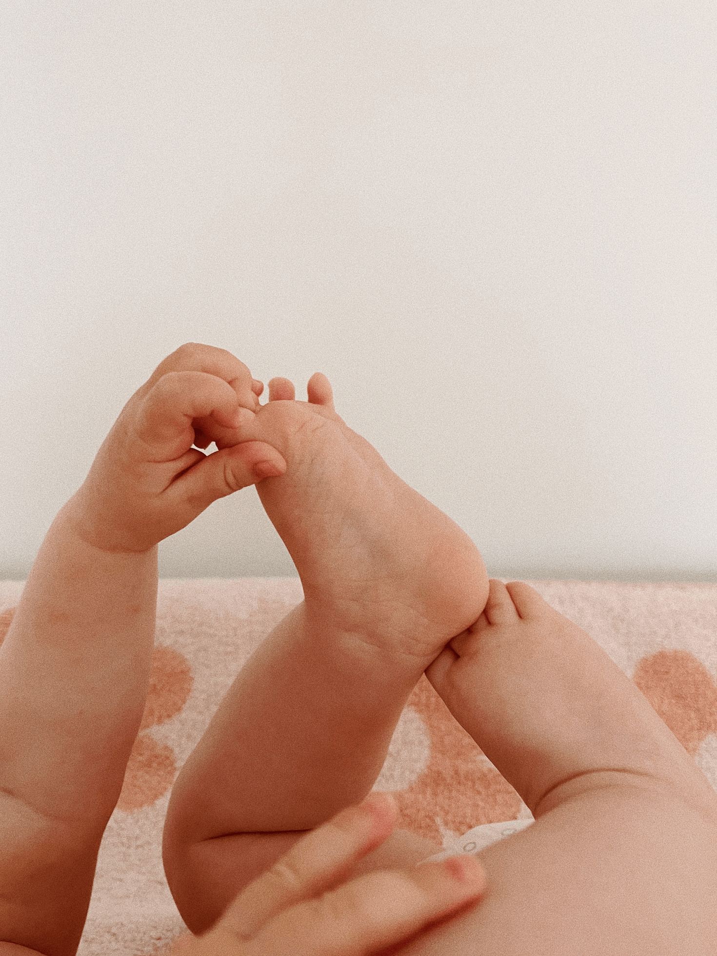 baby holding her feet wearing an organic diaper