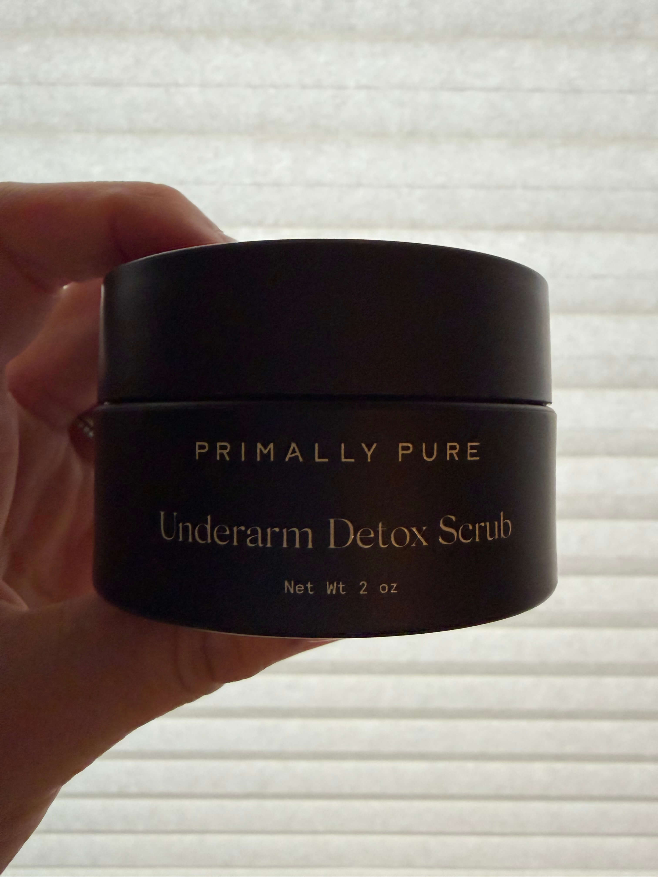 hand holding primally pure underarm detox scrub