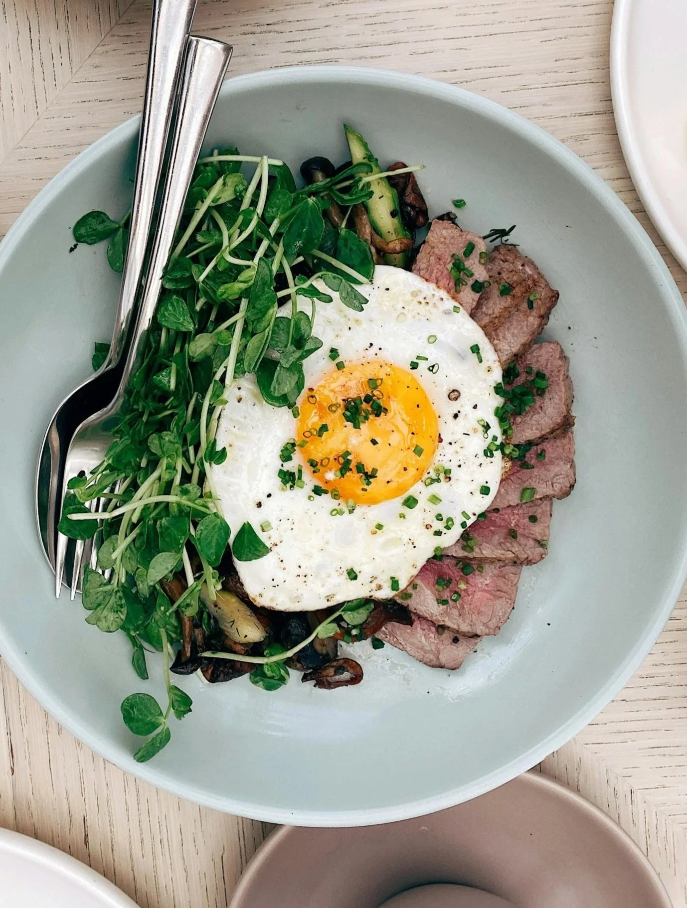 dinner bowl with sliced steak and a fried egg