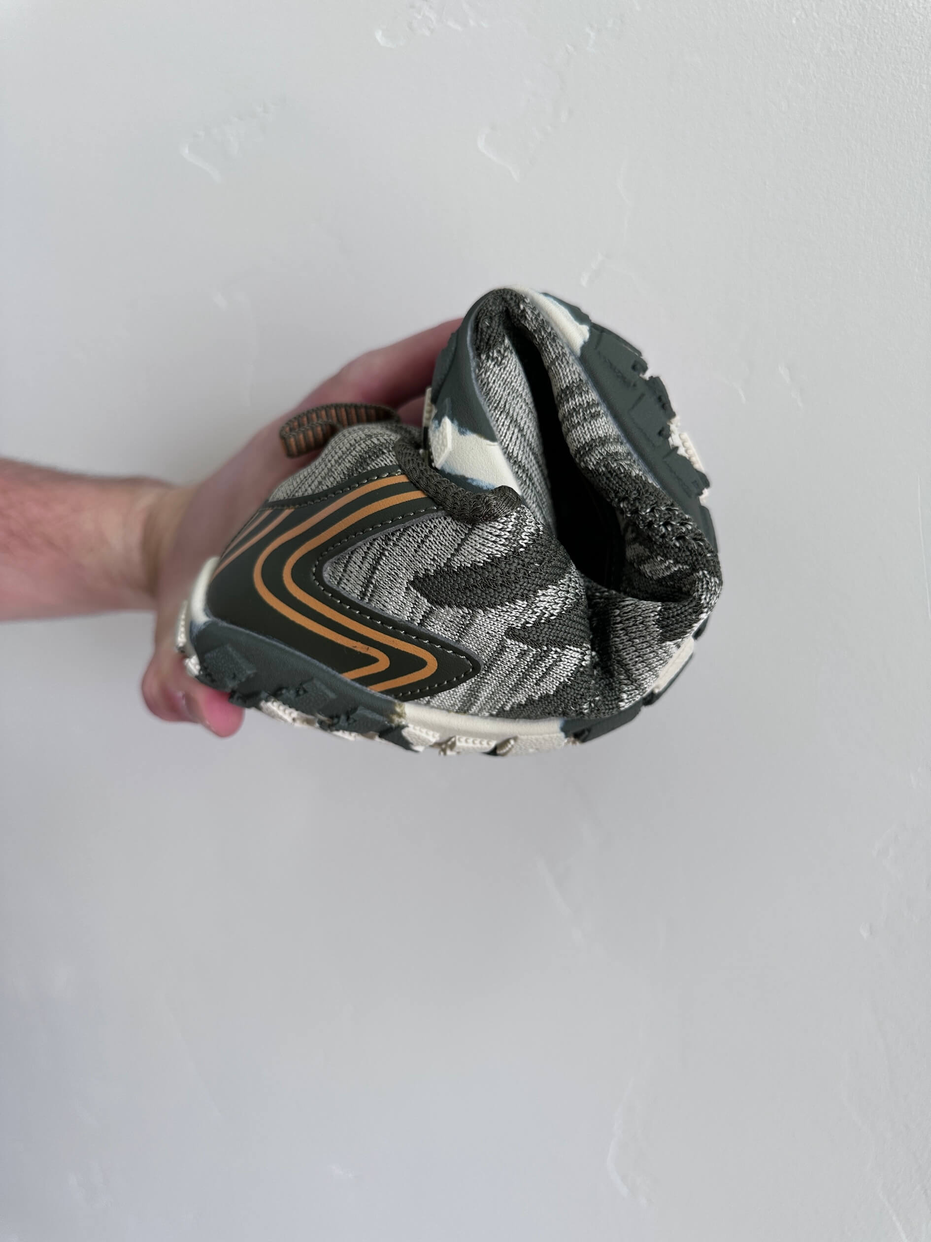 man rolling saguaro active II barefoot shoe showing flexibility
