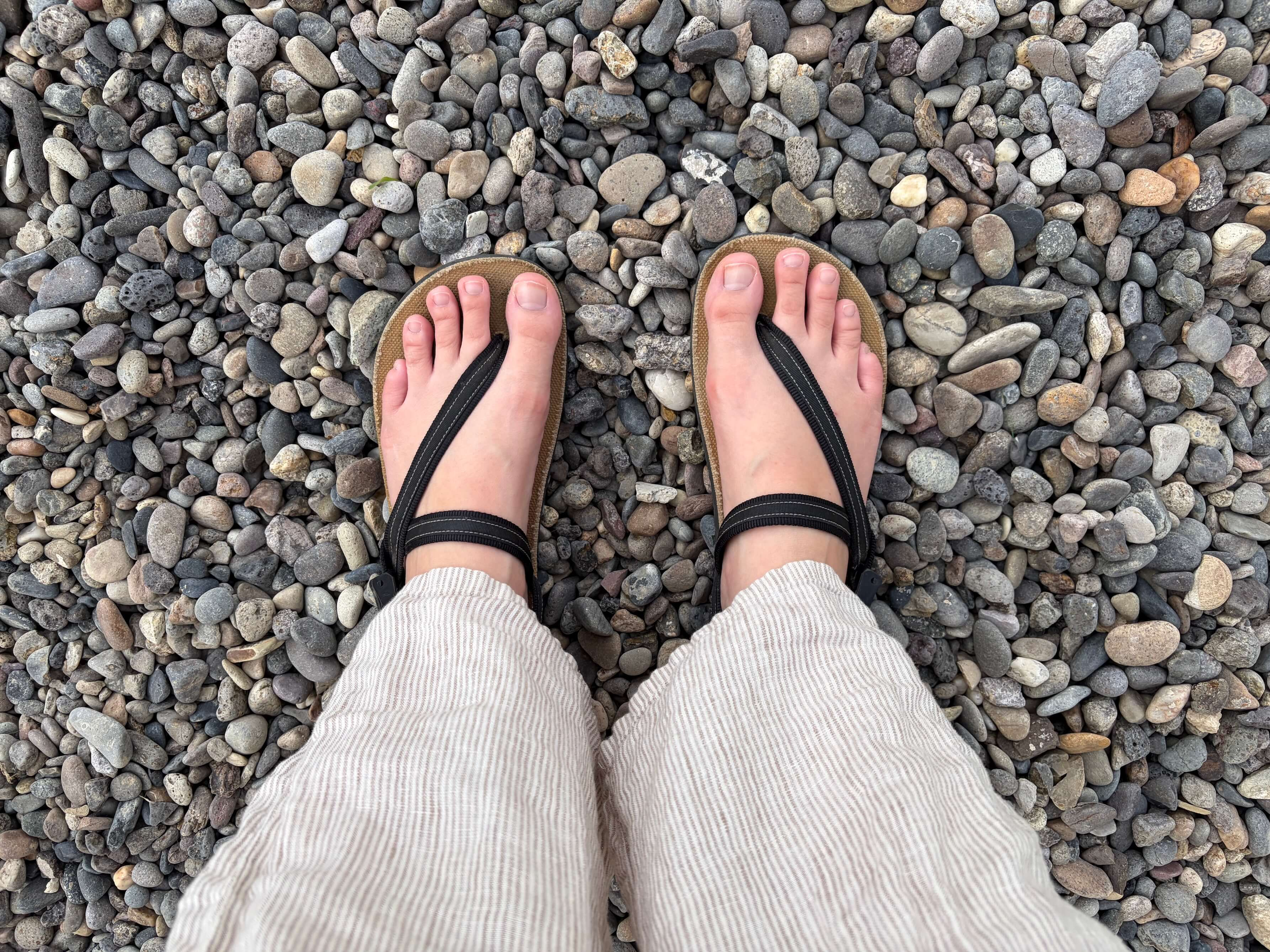 woman wearing Earth Runners Circadian Adventure Sandals standing on rocks