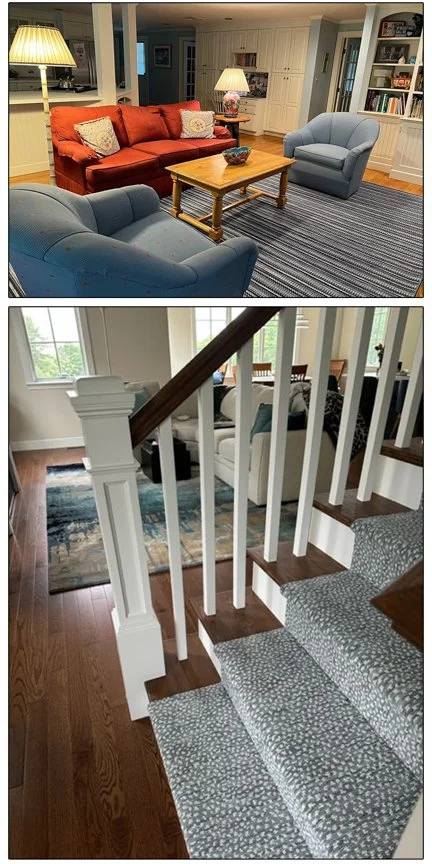 Living room with a red sofa, two blue armchairs, a wooden coffee table, and bookshelves in the background. Stairs with white balusters and a gray patterned carpet runner are visible in the foreground.