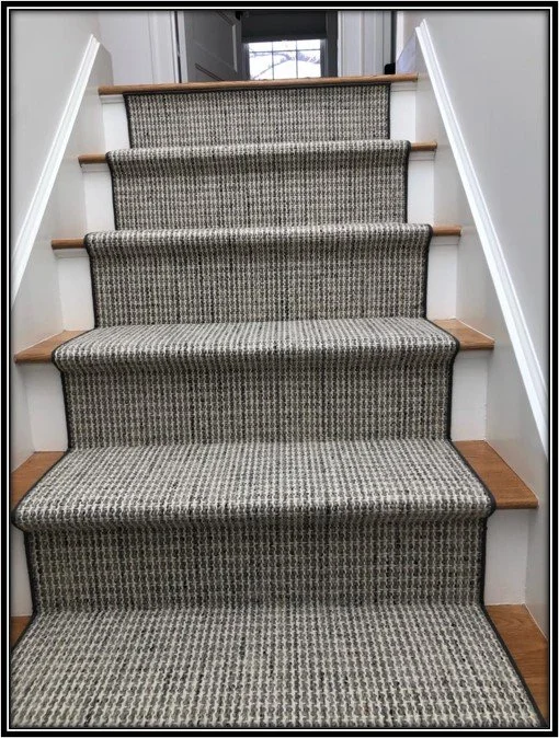 Carpeted staircase with wooden treads, white sidewalls, and a window at the top of the stairs.