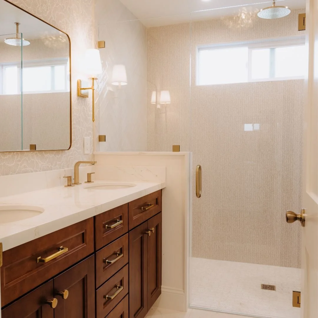 From demo day to the last brass pull&mdash;this master bath was a full design + build by our team. Warm wood cabinetry, mitered quartz tops, herringbone tile, and a seamless walk-in shower = everyday spa vibes 

Ready to love your morning routine? DM