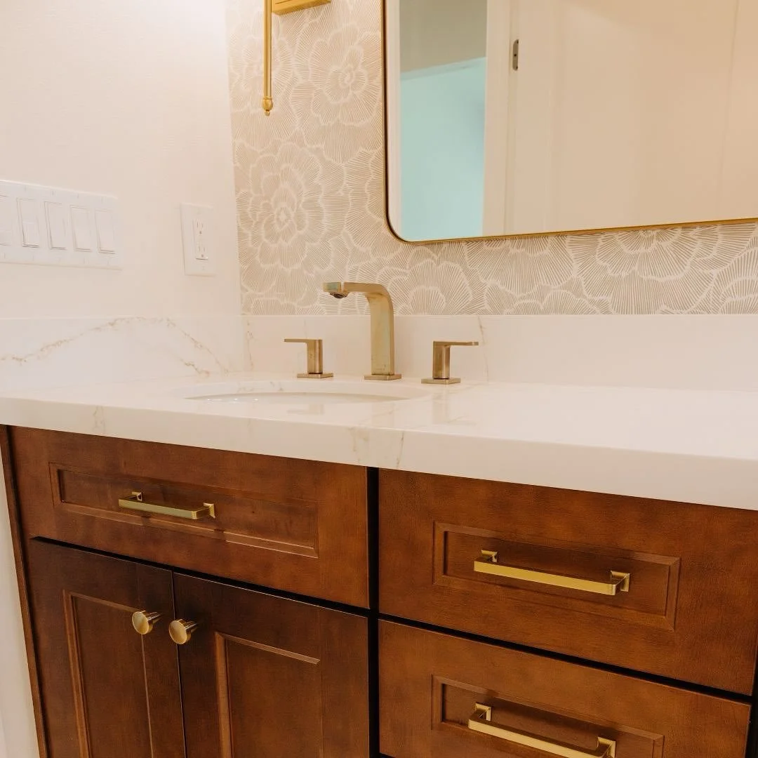This master bath remodel is a balance of elegance and craftsmanship &mdash; from the custom wood cabinetry to the soft veining of the countertops and the warm brass finishes that tie it all together. Every design choice was intentionally built and be