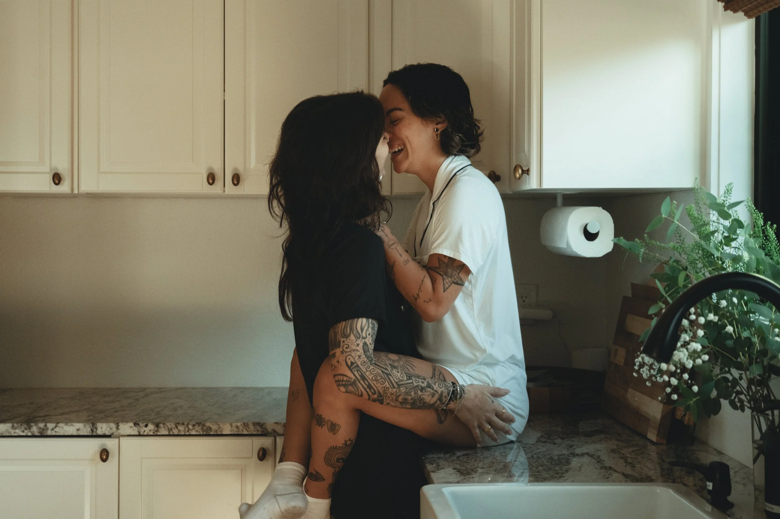 Wedding photo of a couple laughing in the kitchen before their wedding