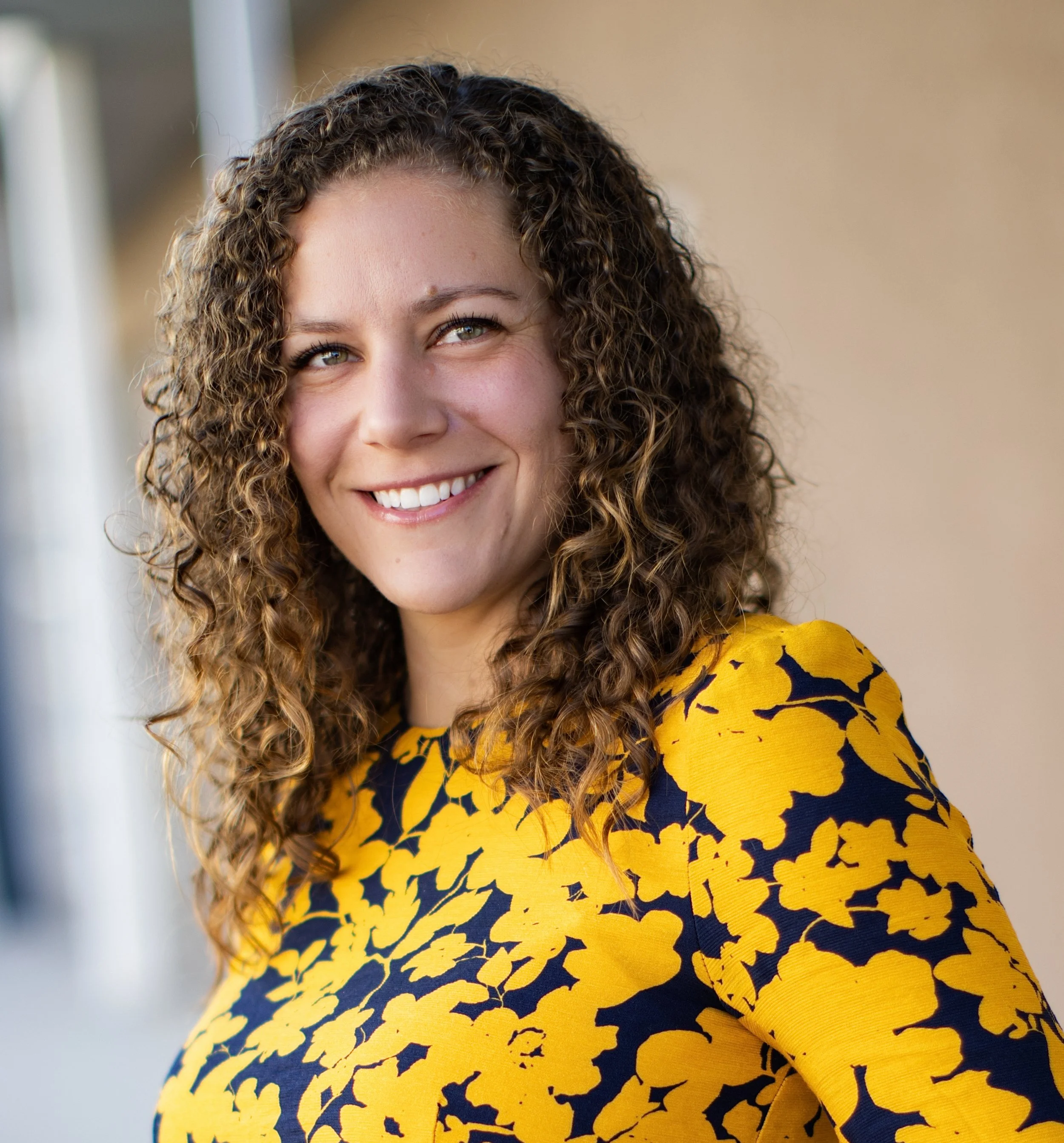 Rebecca Justus outside wearing a yellow and navy top