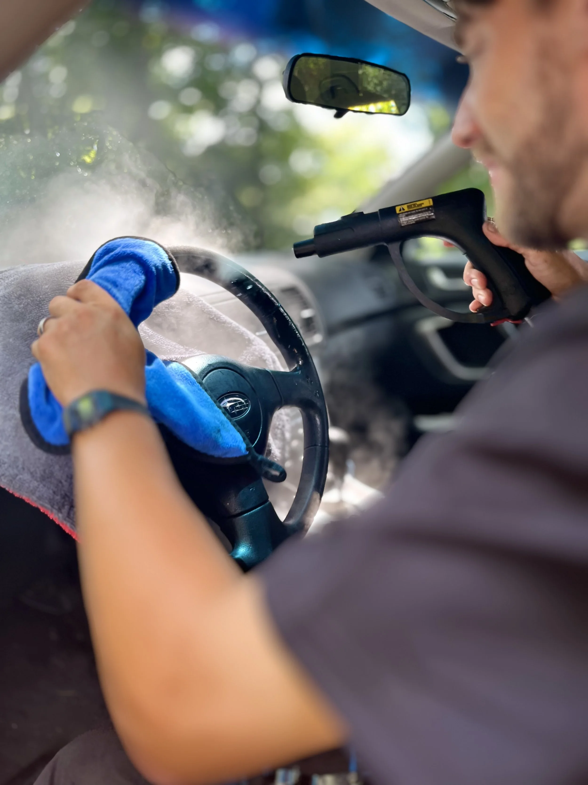 mobile detailer cleaning steering wheel with steamer