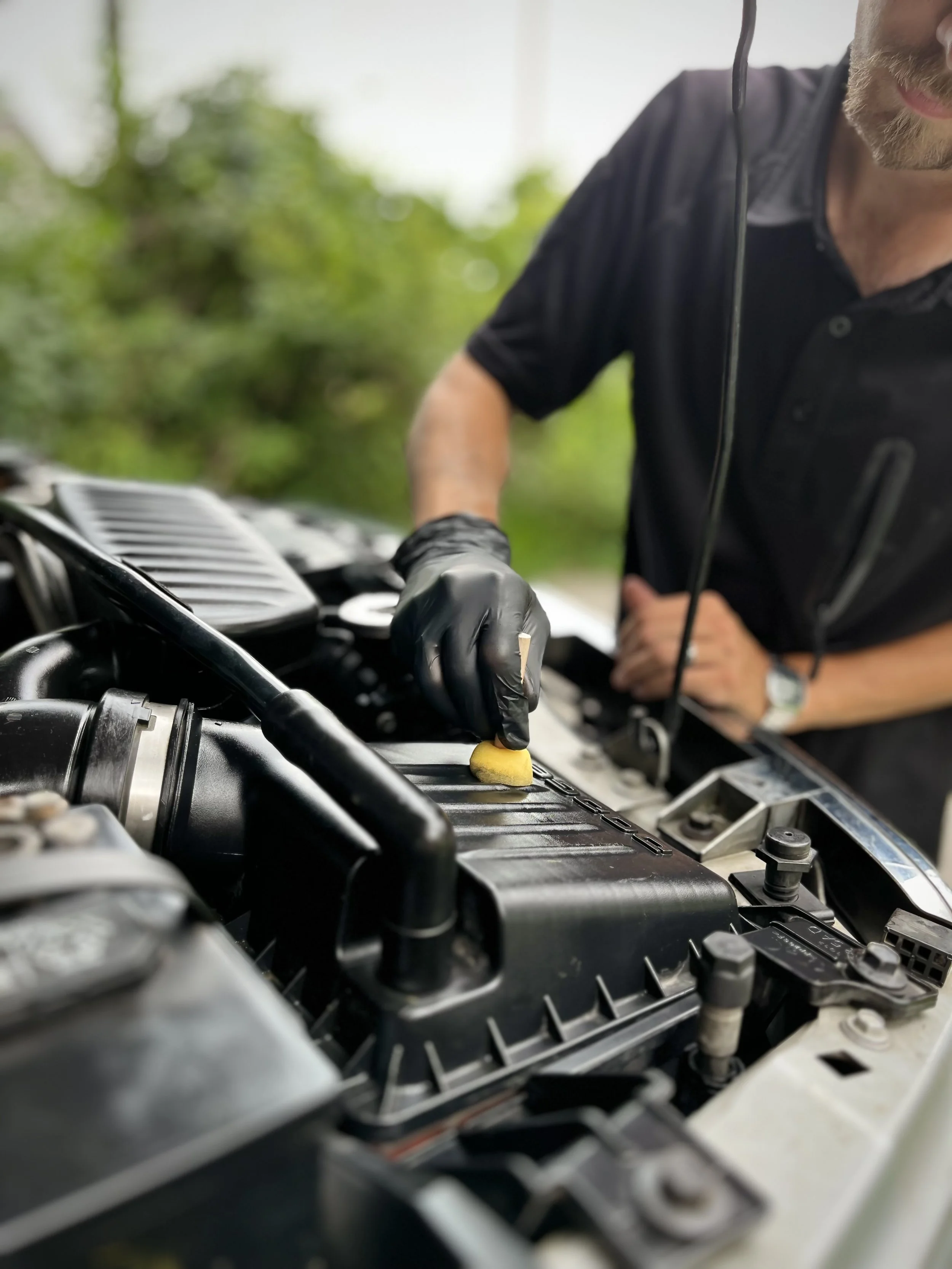 Mobile detailer cleaning engine bay gently