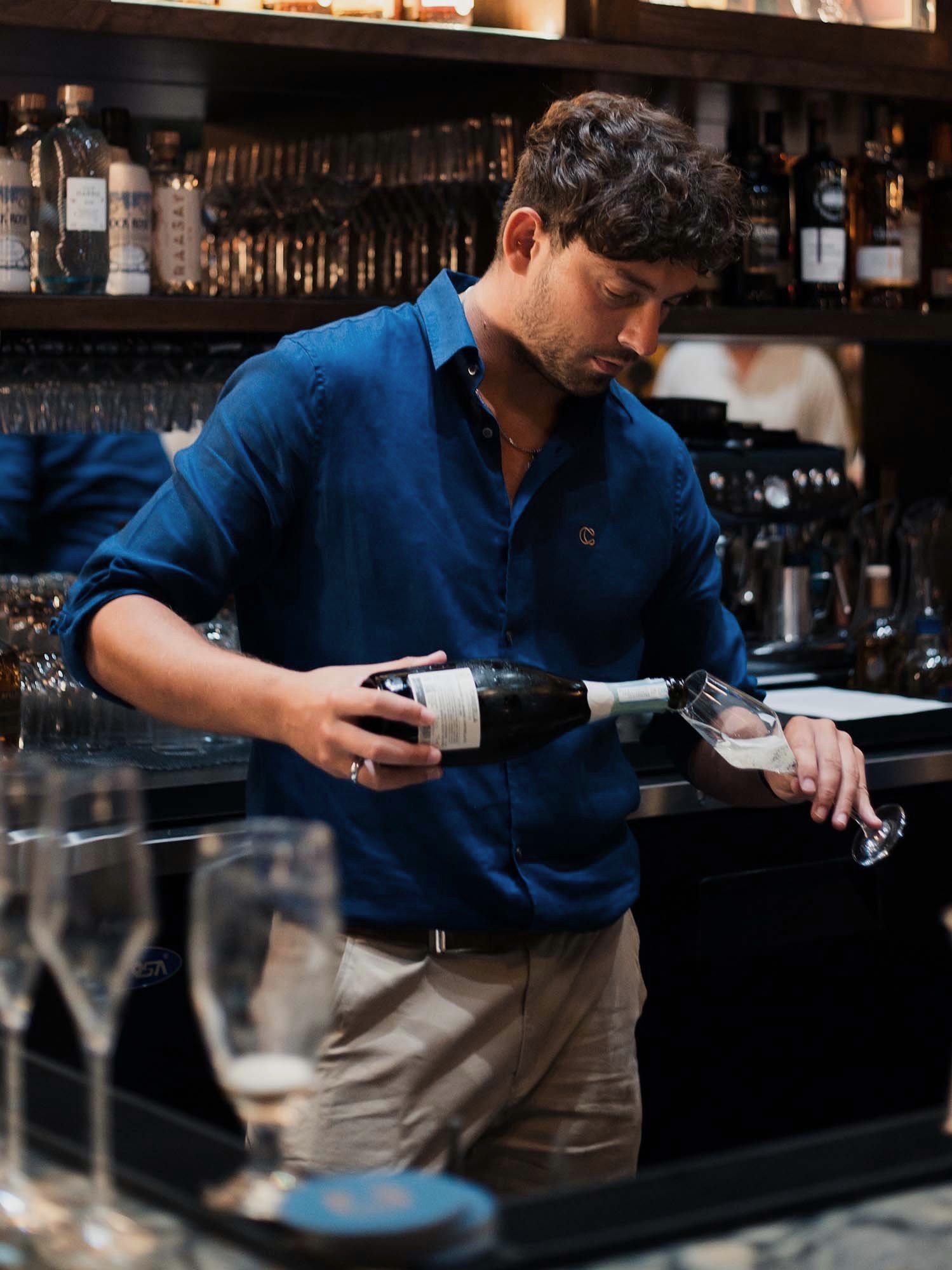 Bartender preparing drinks at the fully stocked bar at Cask in Grand Cayman