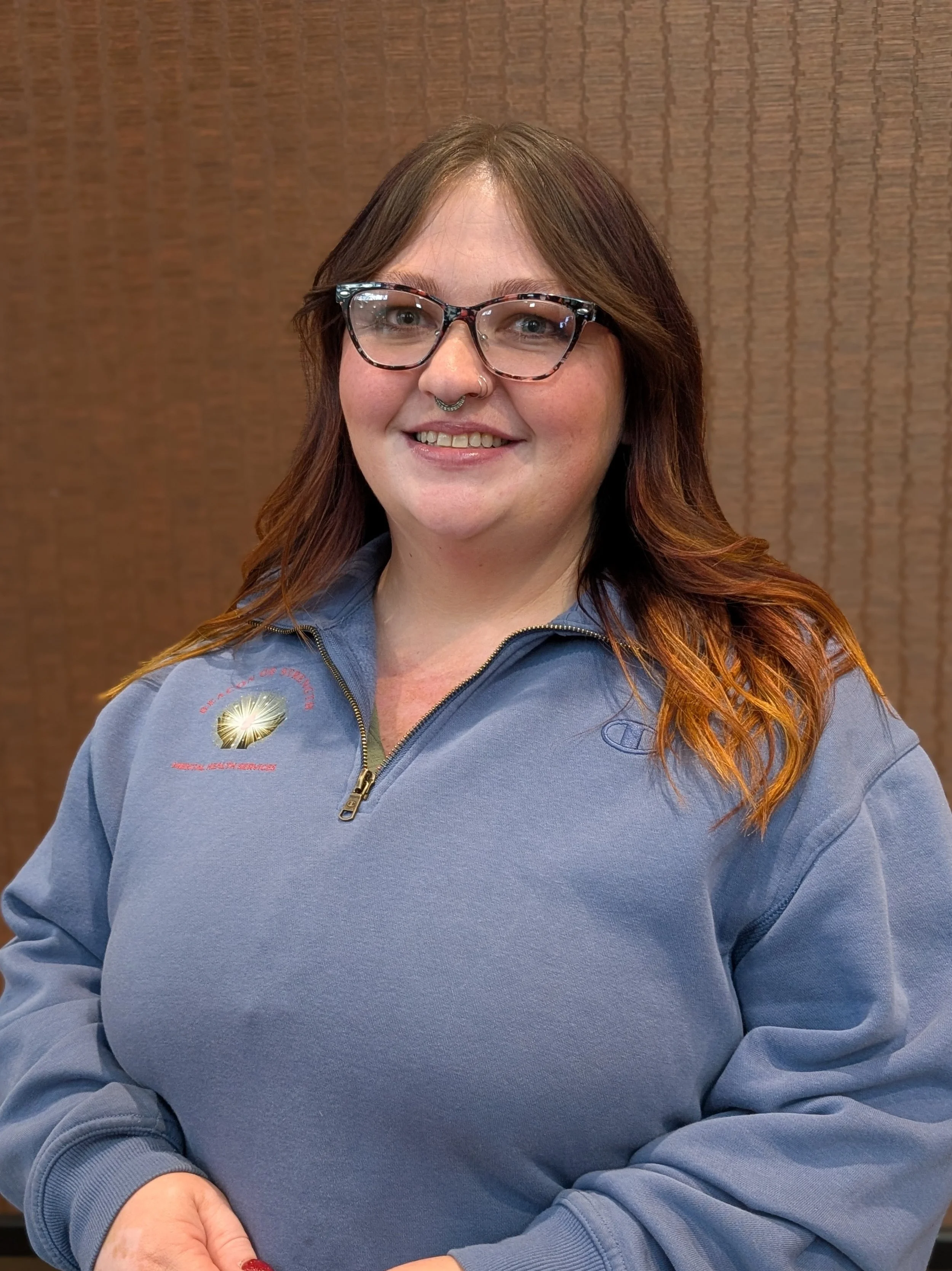 Close-up of Adelia Kindstrand-Clark, LGSW, who has red hair, soft facial features and a welcoming smile.