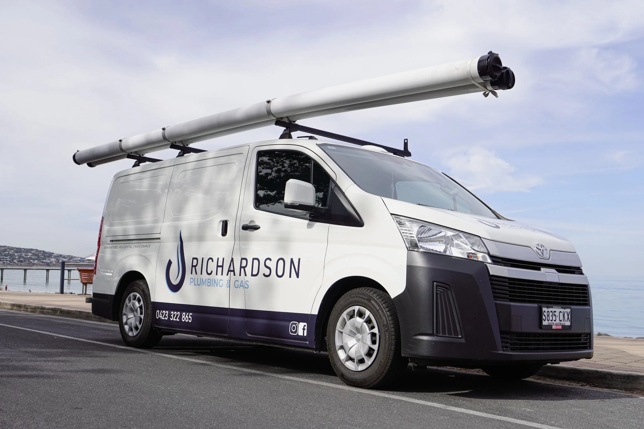 A Richardson Plumbing and Gas work van parked on the esplanade at Brighton, Adelaide