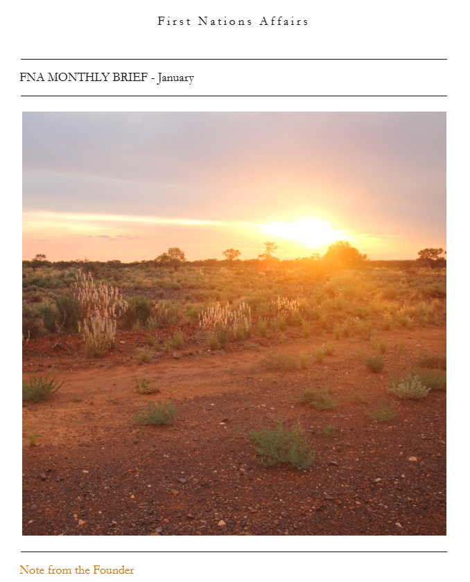 Sunset over a desert landscape with sparse vegetation and small bushes.