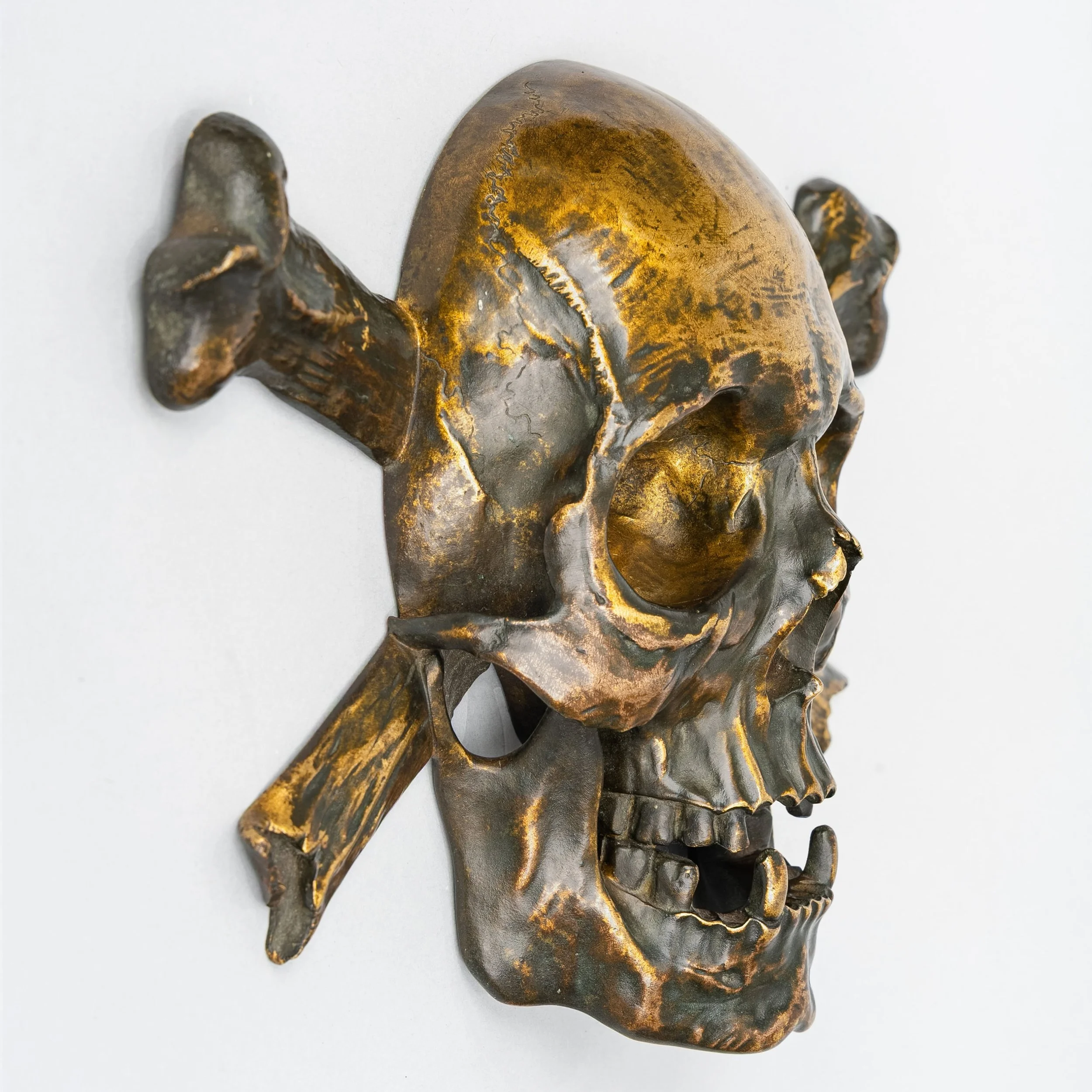 Side profile of a French gilt bronze memento mori skull and crossed bones, 19th century — Daniels Antiques