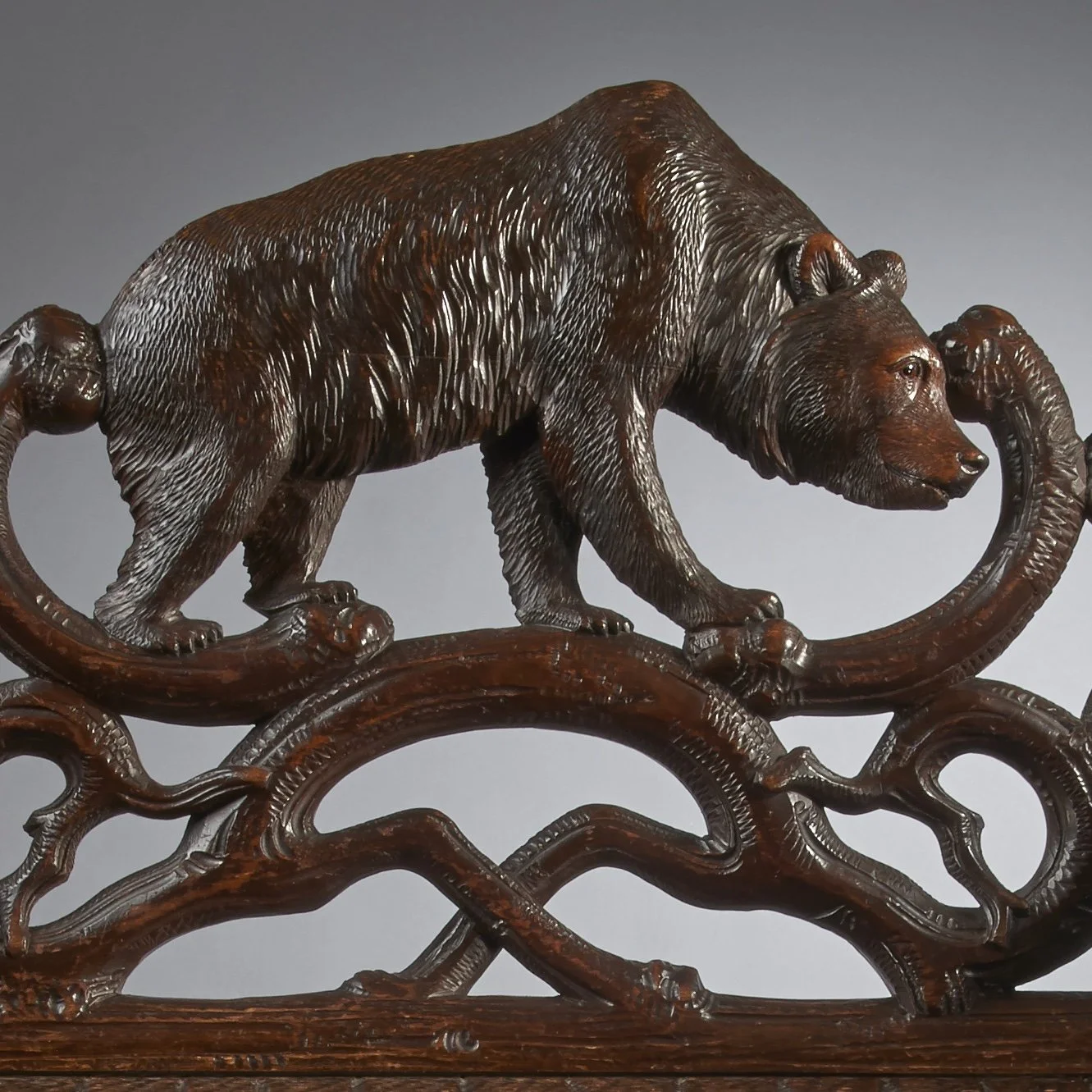Carved linden wood strolling bear on the crest rail of a Swiss Black Forest bear bench, circa 1870