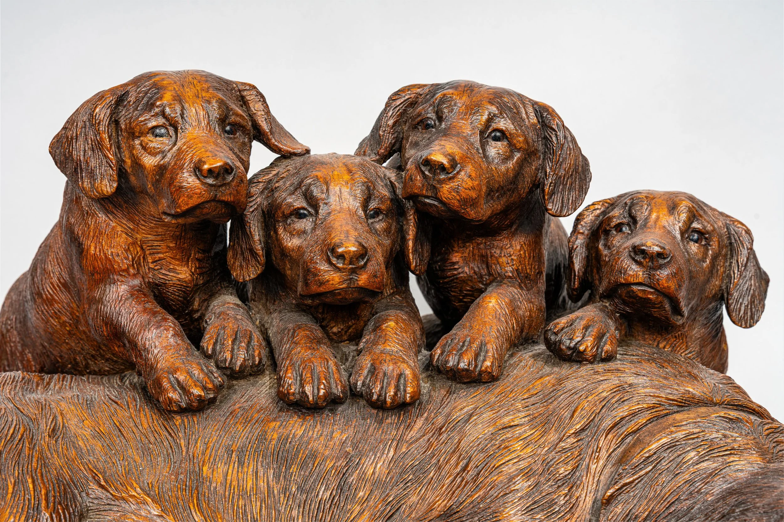 Detail of four individually characterized pups, Swiss Black Forest carved walnut hound group, Walter Mader, Brienz circa 1870
