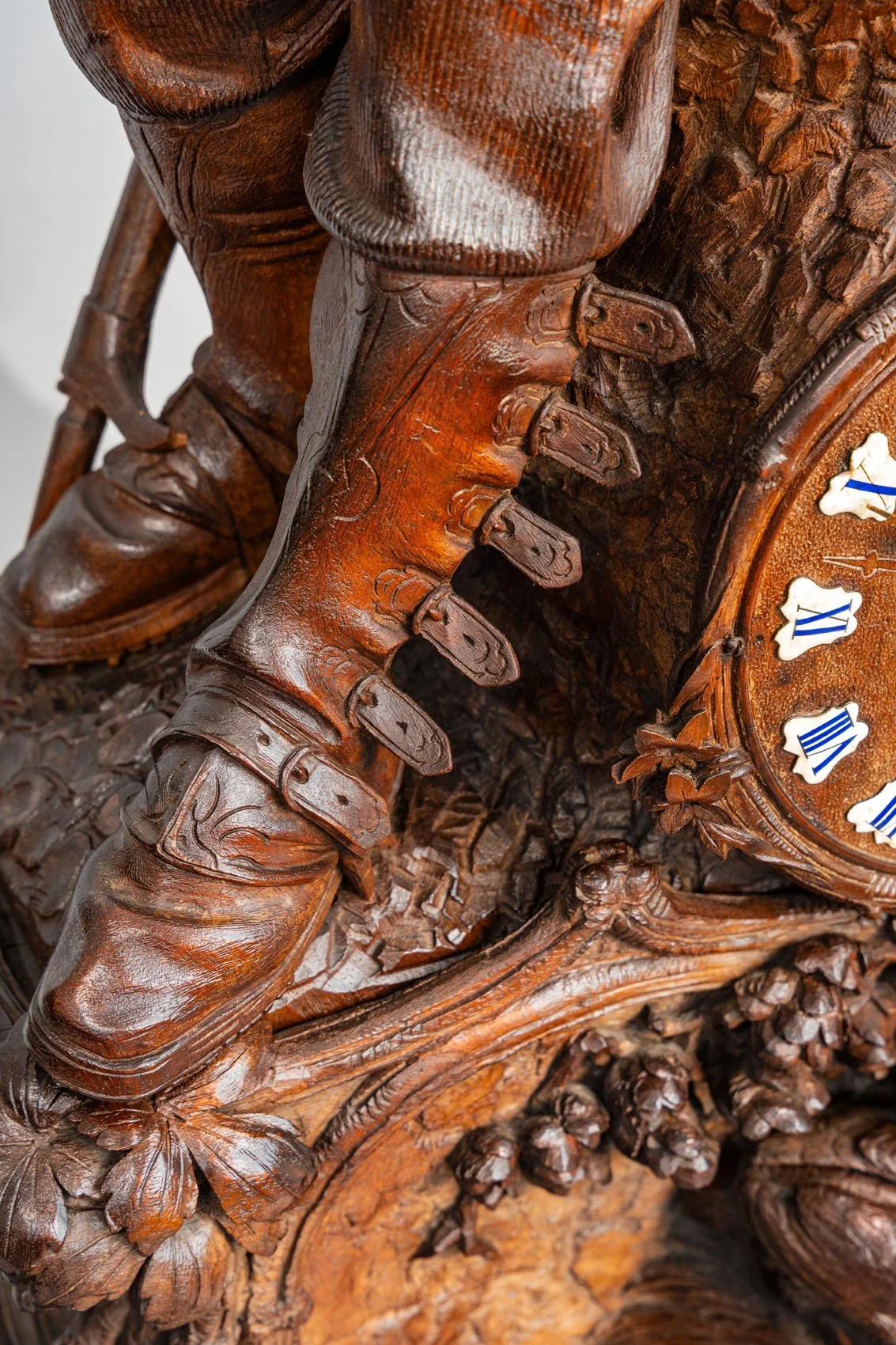 Detail of carved buckled hunting boots and enamel dial, Swiss Black Forest hunter clock signed J. Huggler, Brienz
