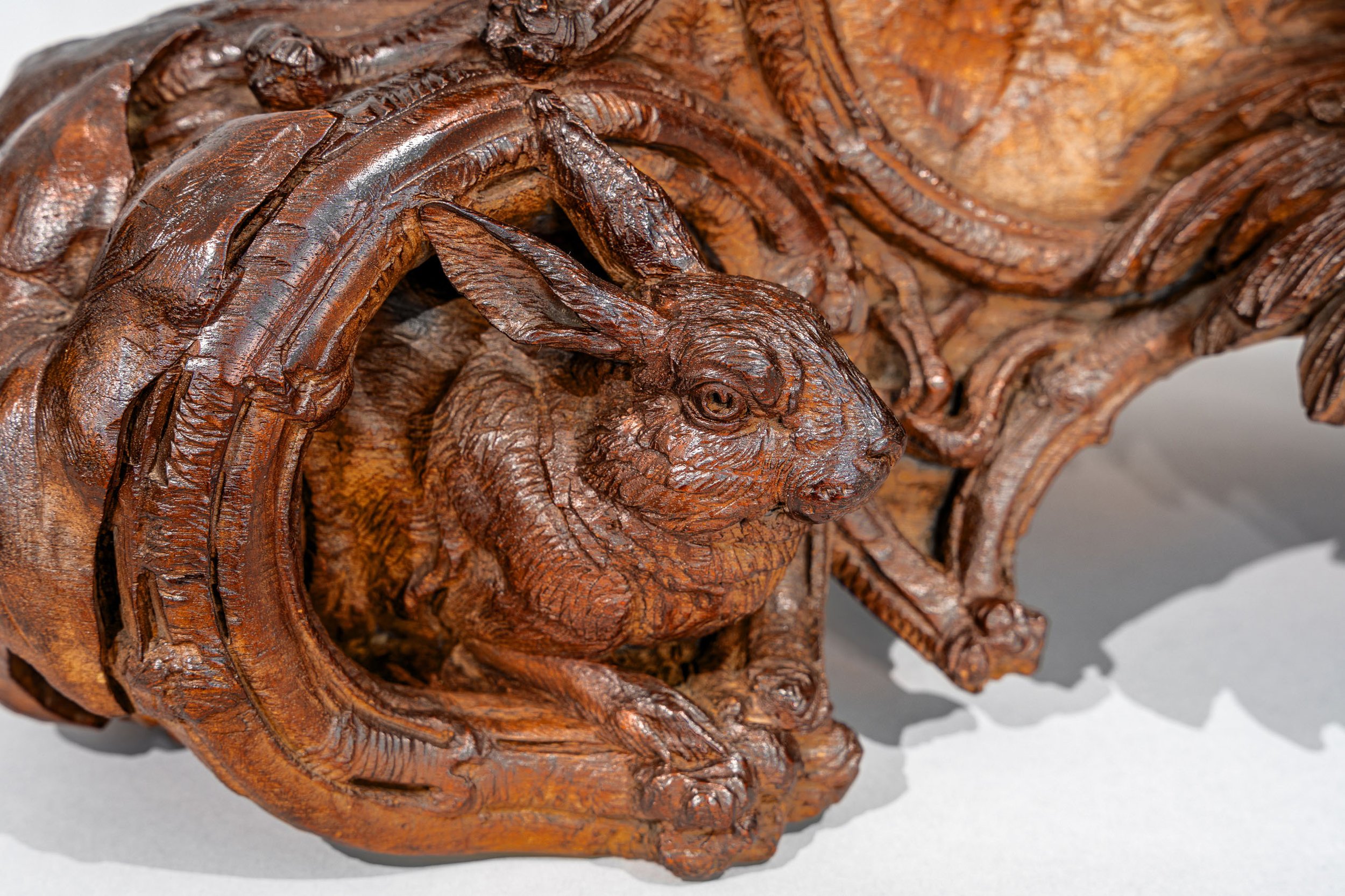 Hare within scrolled cartouche, base detail, Swiss Black Forest hunter clock signed J. Huggler, Brienz