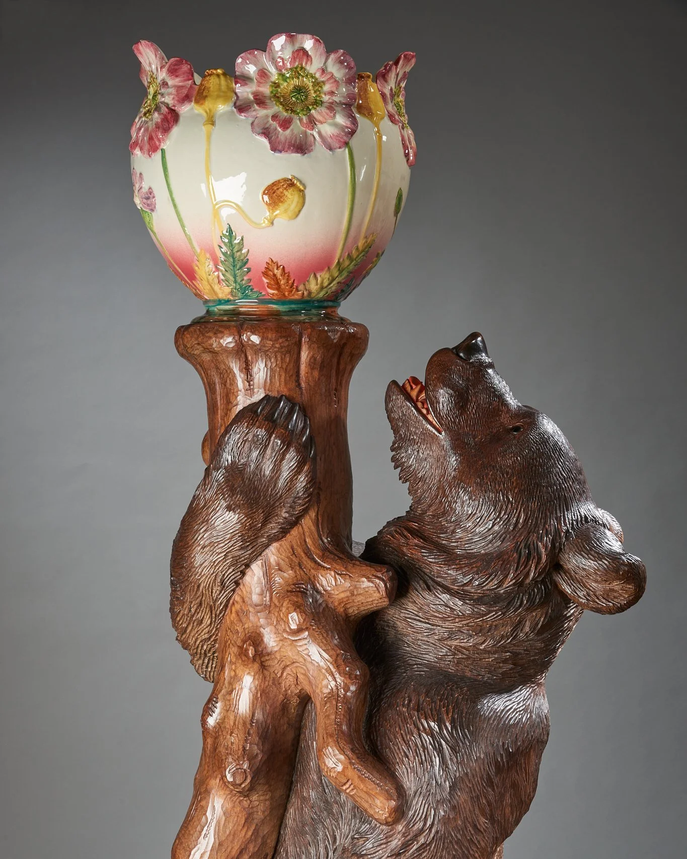 Swiss Black Forest carved walnut bear jardinière stand with a majolica bowl, Brienz, circa 1900. Illustrated in Swiss Carvings: The Art of the Black Forest, 1820–1940, plate 00.